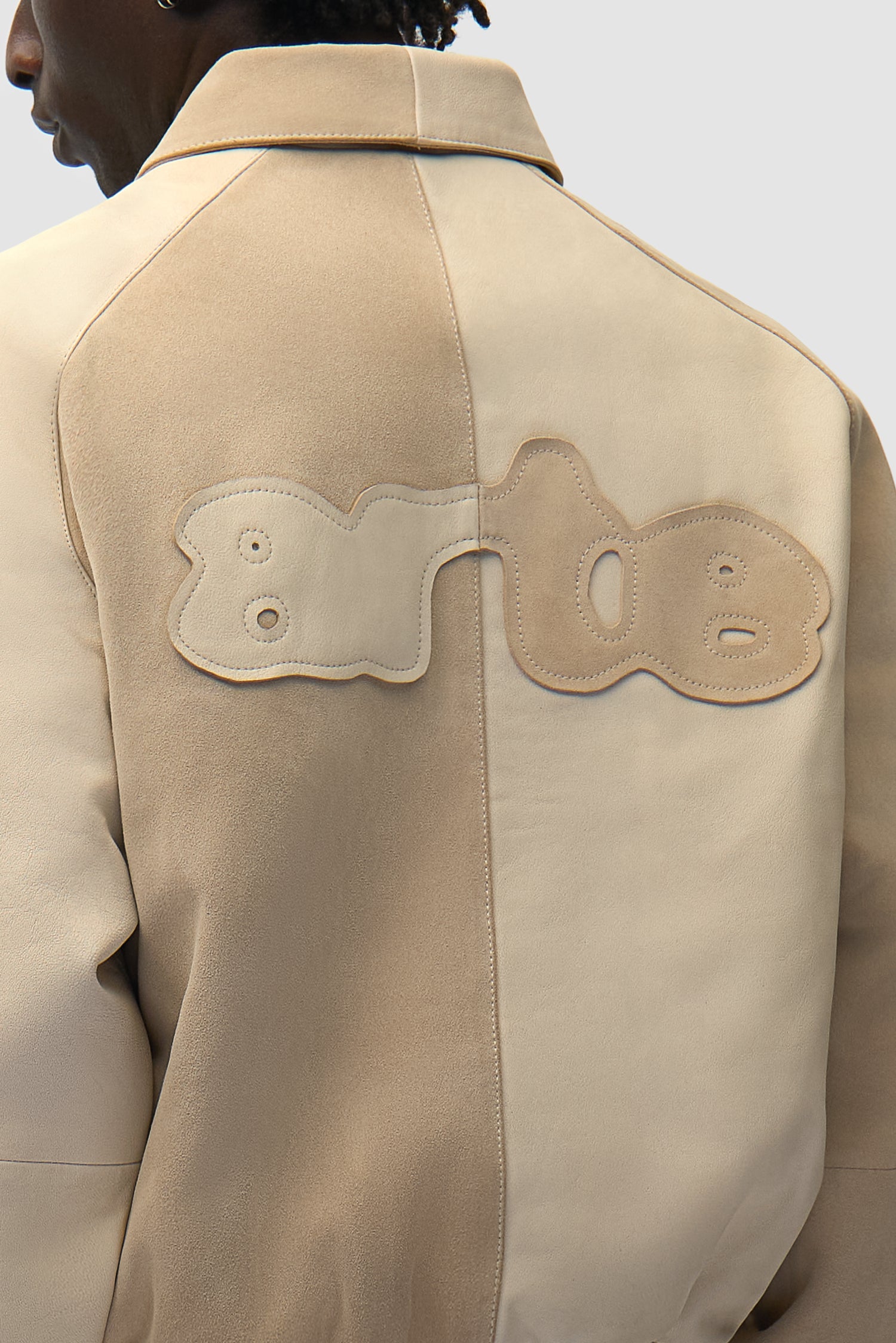 Vue détaillée de la veste Multi Leather Jacket en crème, avec logo