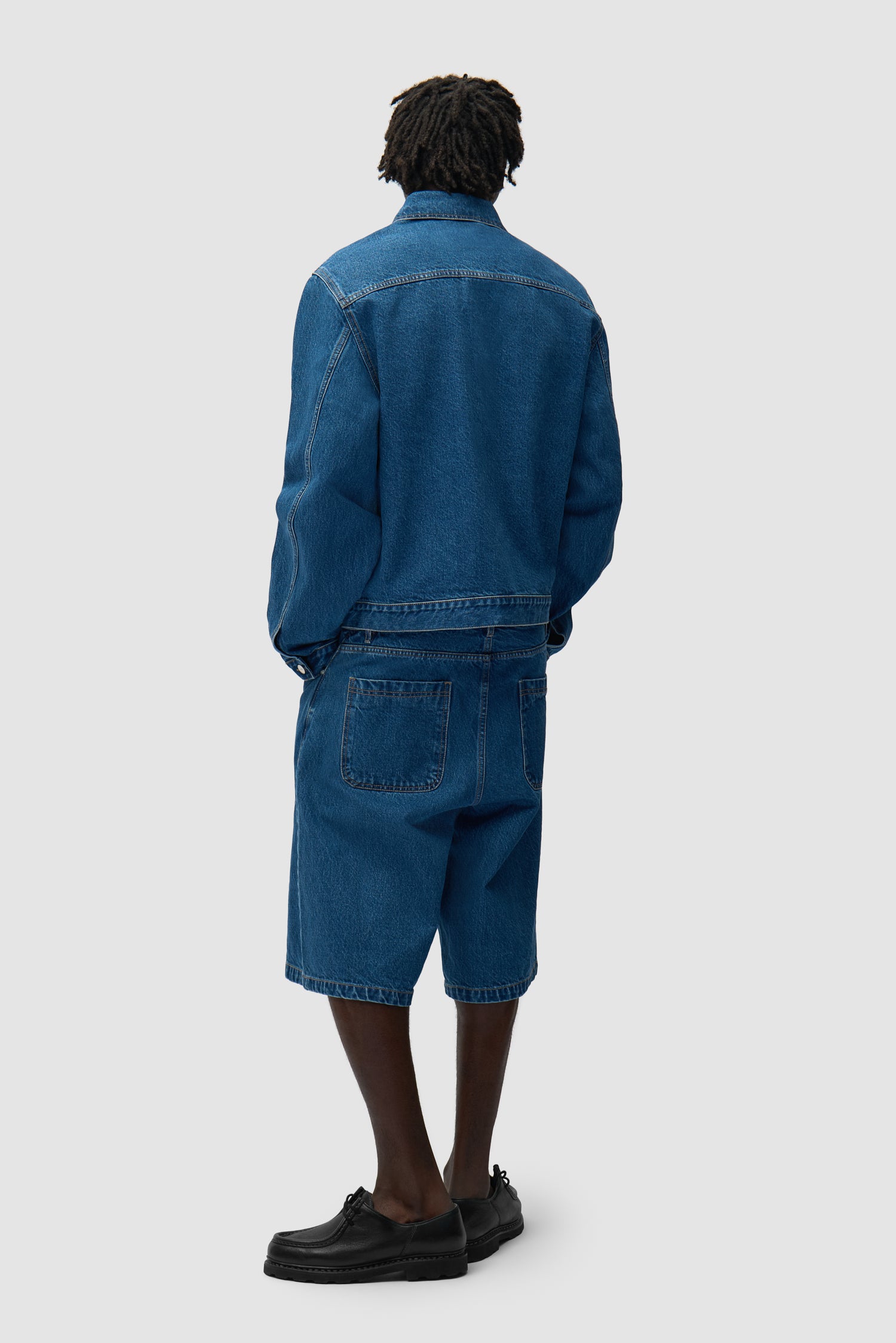 Short en denim brut à poche ronde porté par un mannequin, vue de face en pied