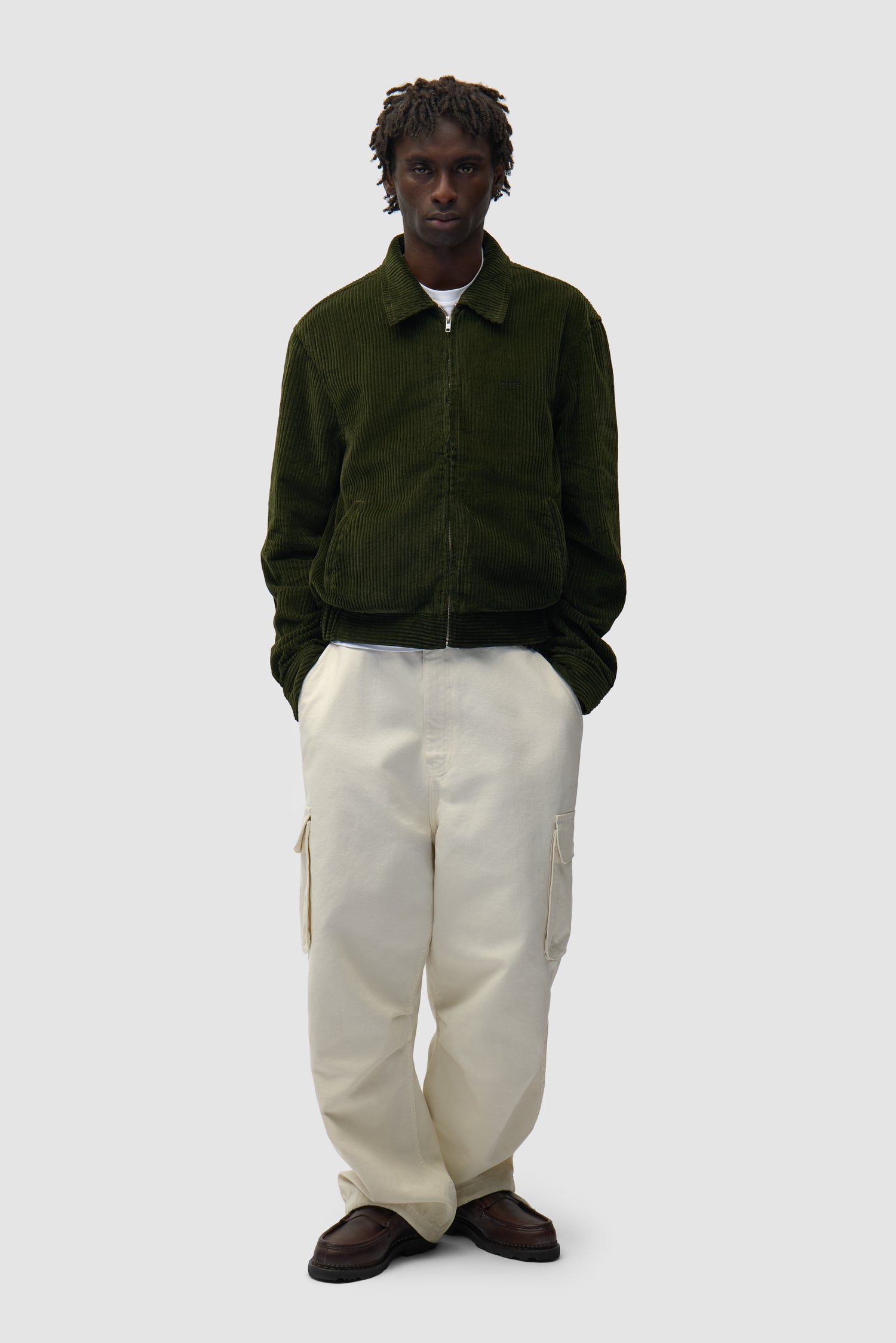 Veste en velours côtelé verte portée par un mannequin, vue de face en pied