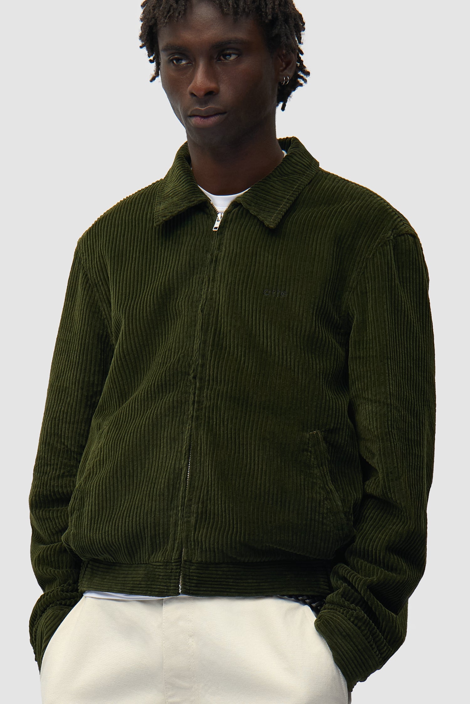 Veste en velours côtelé verte portée par un mannequin, vue de profil à mi-corps