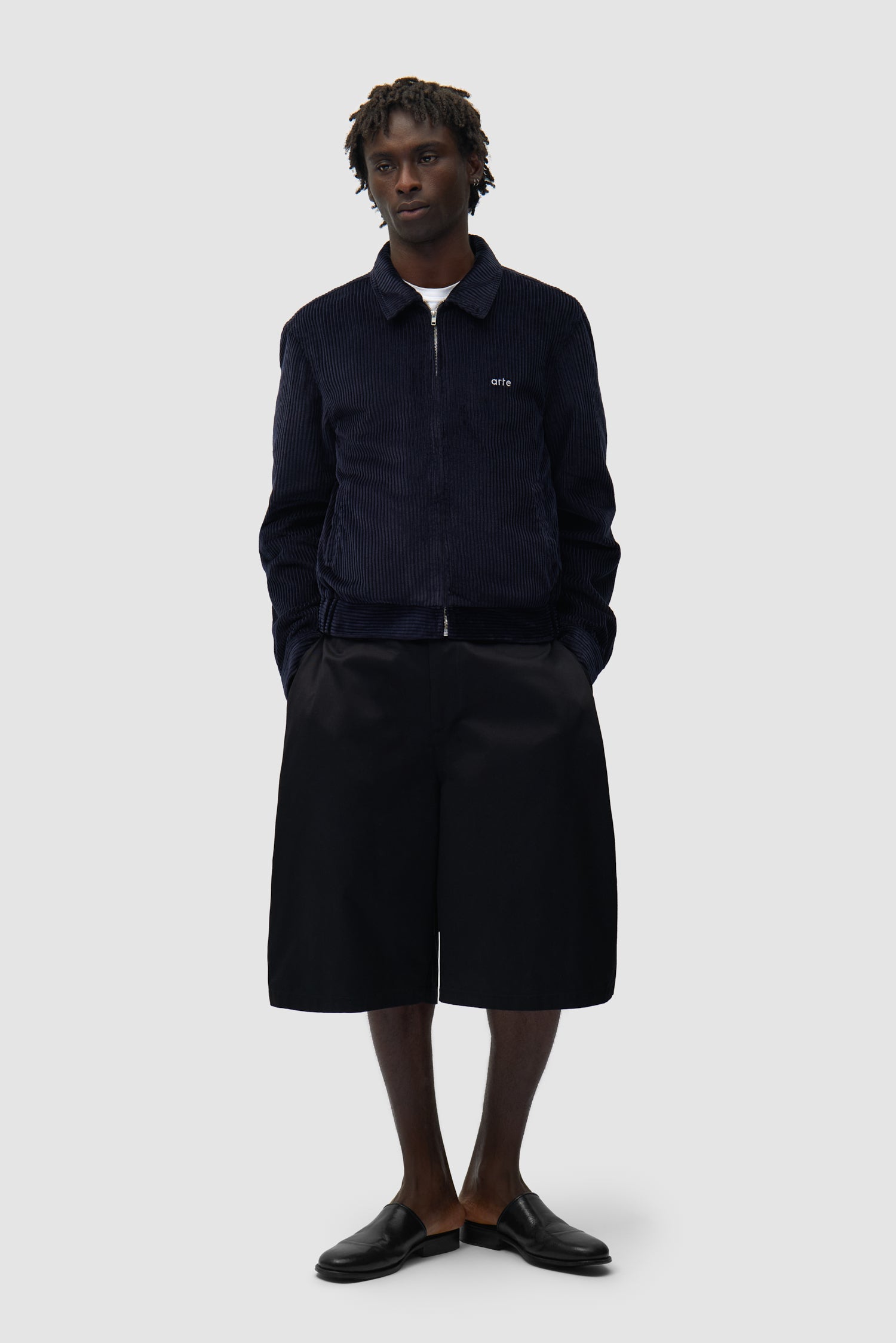 Veste en velours côtelé bleu marine portée par un mannequin, vue de profil en pied