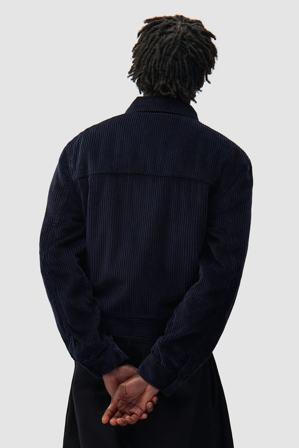 Corduroy Jacket in Navy worn by a model, half-body back view