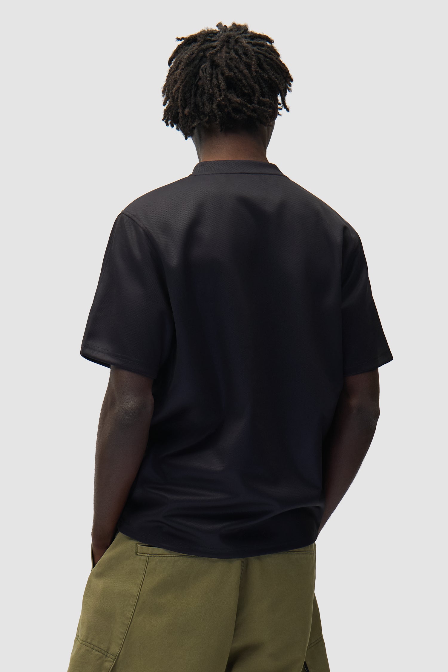 T-shirt de football noir porté par un mannequin, vue de dos à mi-corps