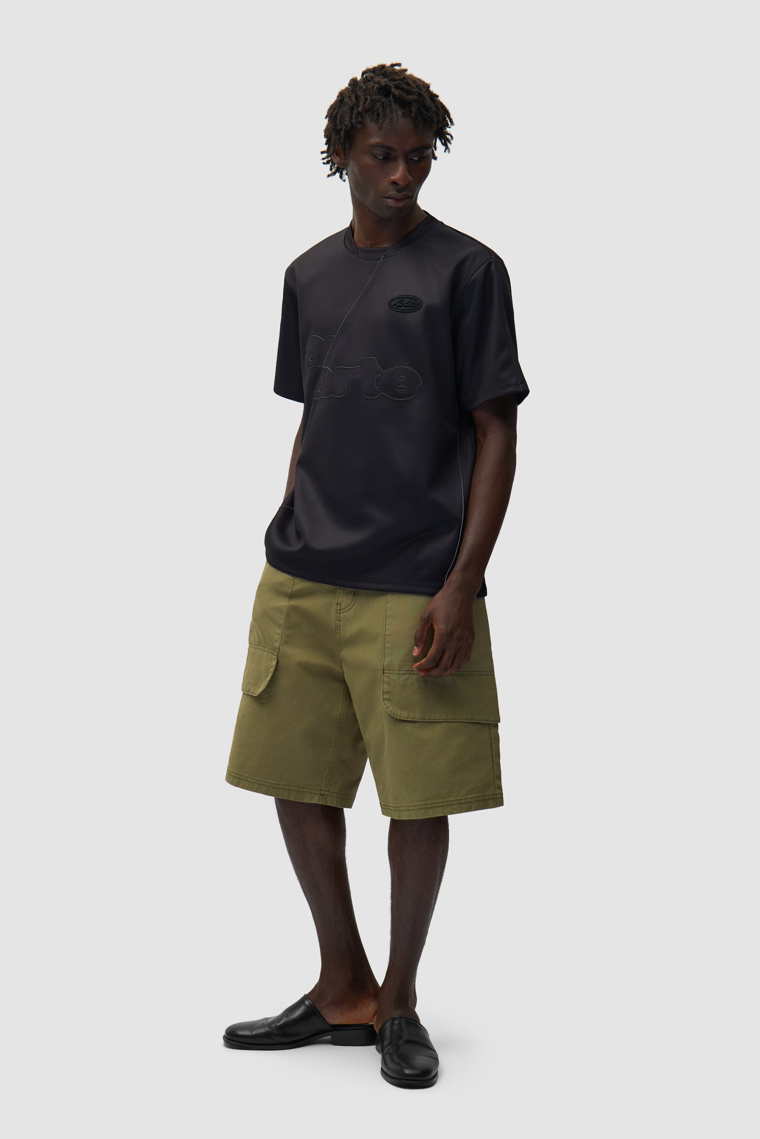 T-shirt de football noir porté par un mannequin, vue de profil en pied