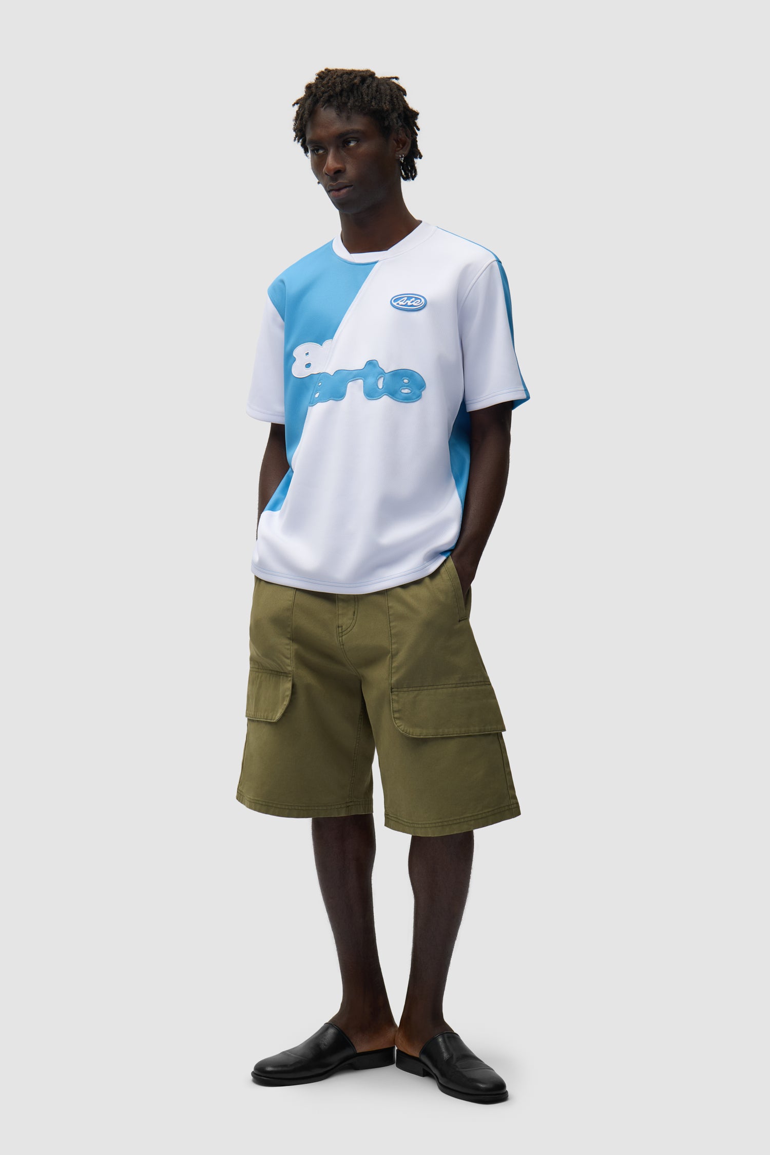 T-shirt de football bleu et blanc porté par un mannequin, vue de profil en pied