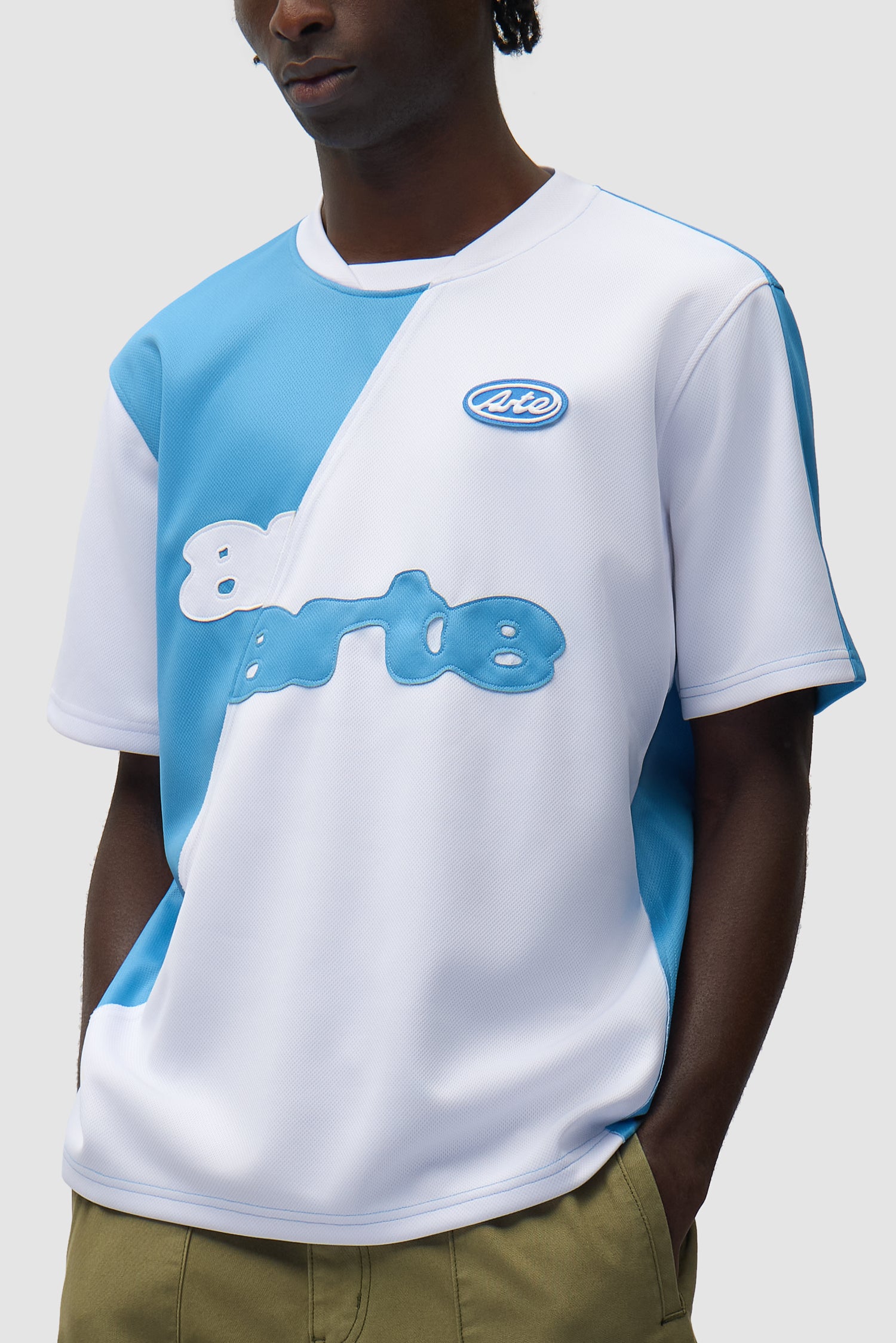 T-shirt de football bleu et blanc porté par un mannequin, vue de profil à mi-corps