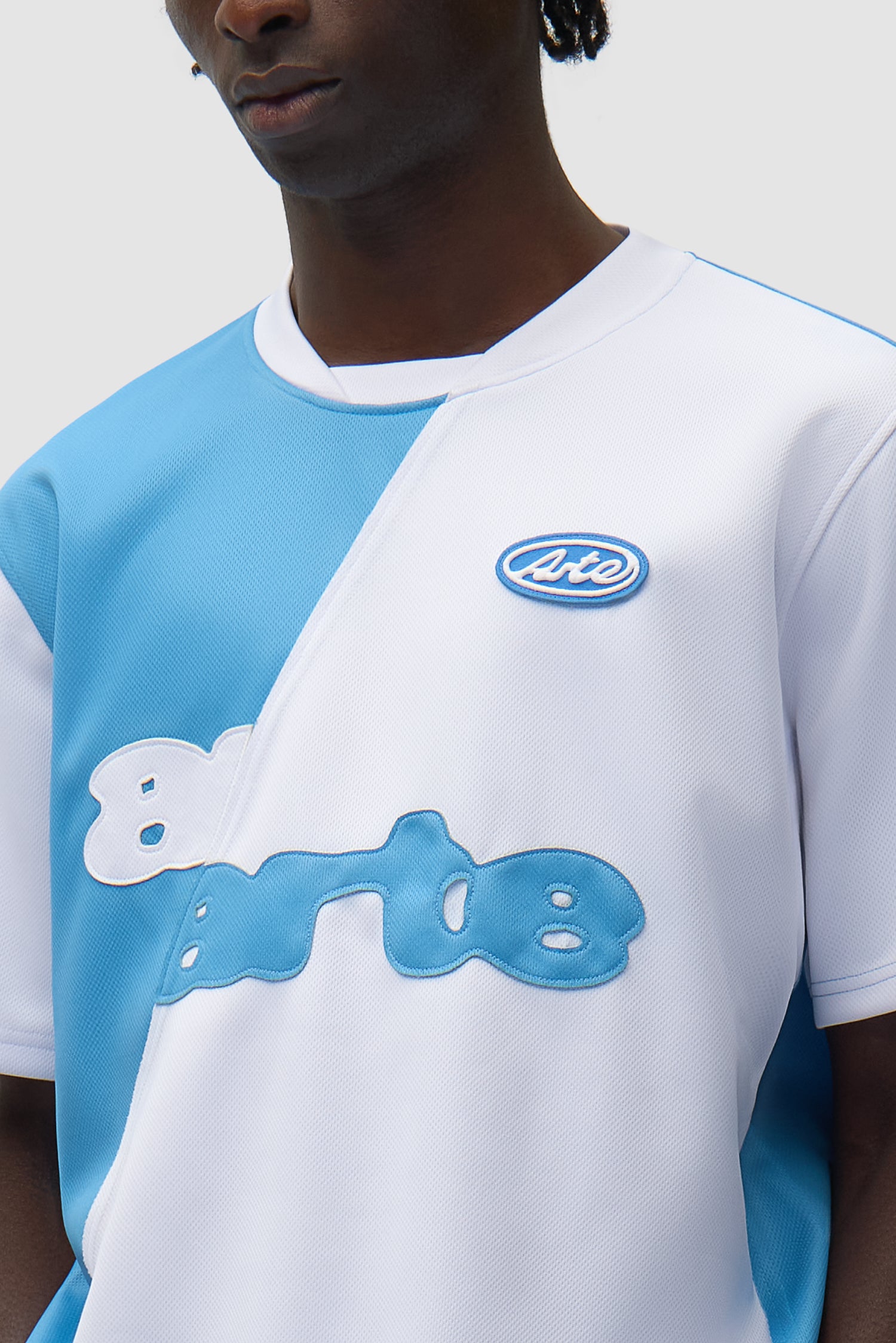 Vue détaillée du t-shirt de football bleu et blanc, avec logo sur le devant