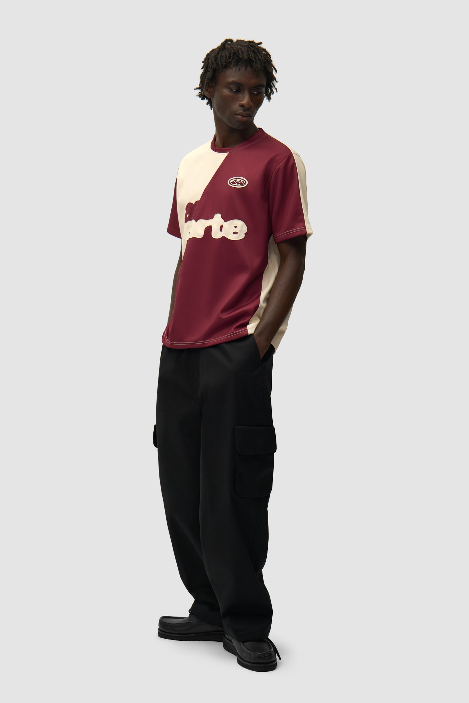 T-shirt de football bordeaux/crème porté par un mannequin, vue de profil en pied