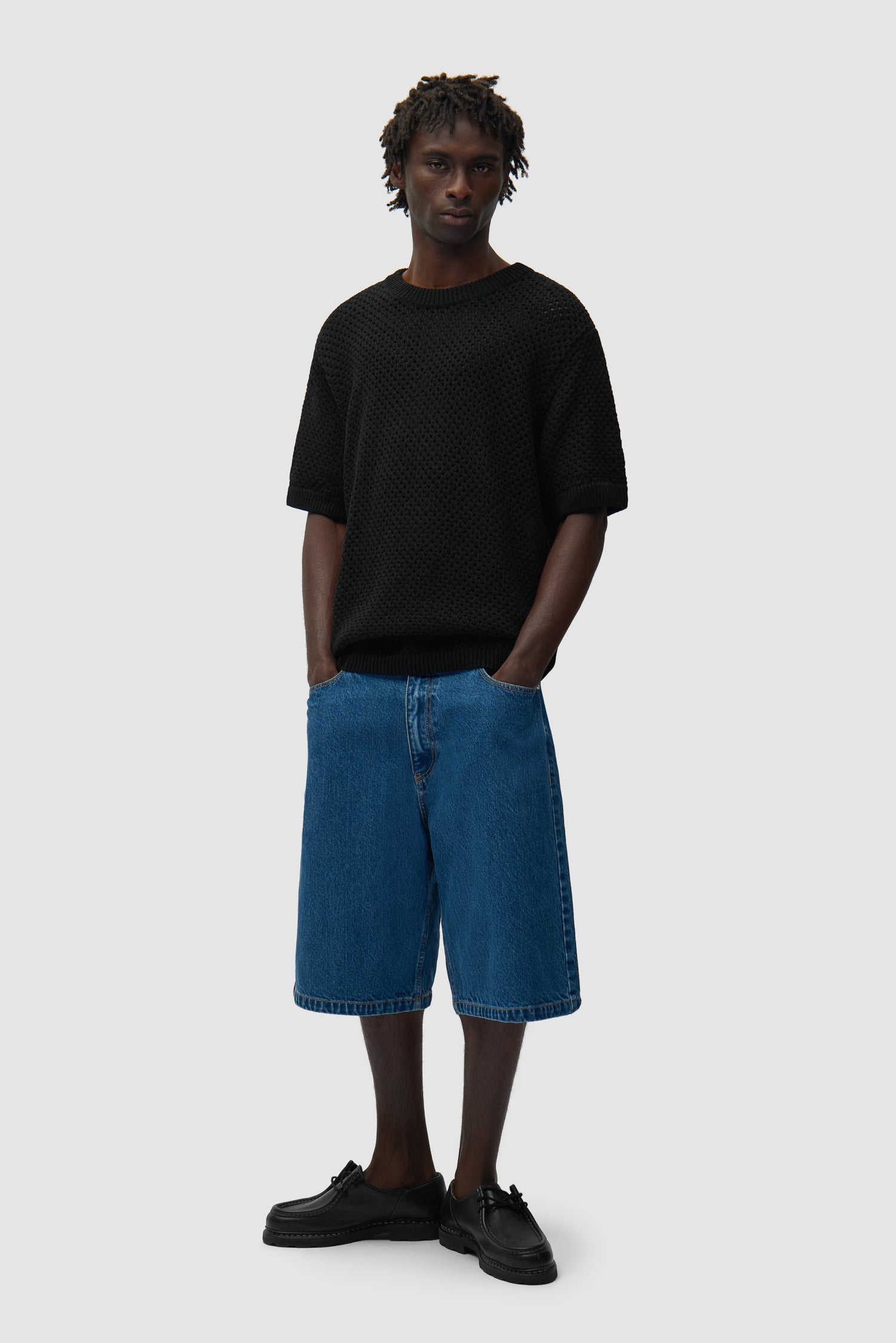 T-shirt noir en crochet porté par un mannequin, vue de profil en pied