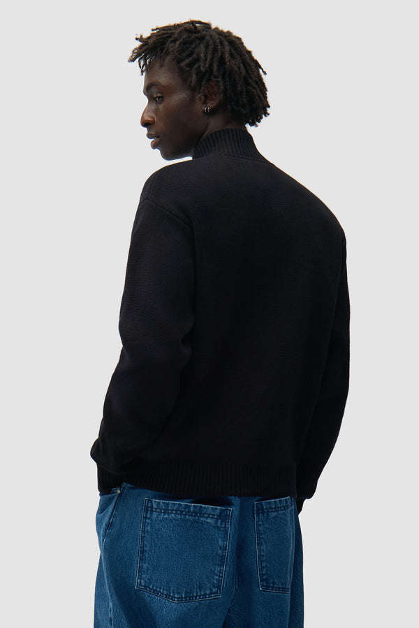 Diels Collar Cardigan in Black worn by a model, half-body back view