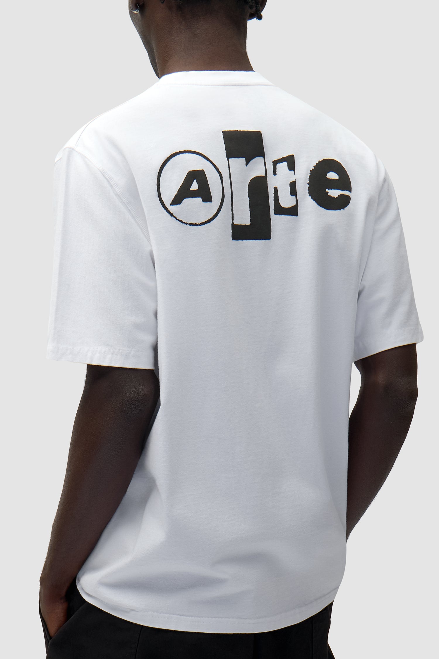 T-shirt blanc à collage dans le dos porté par un mannequin, vue de profil à mi-corps