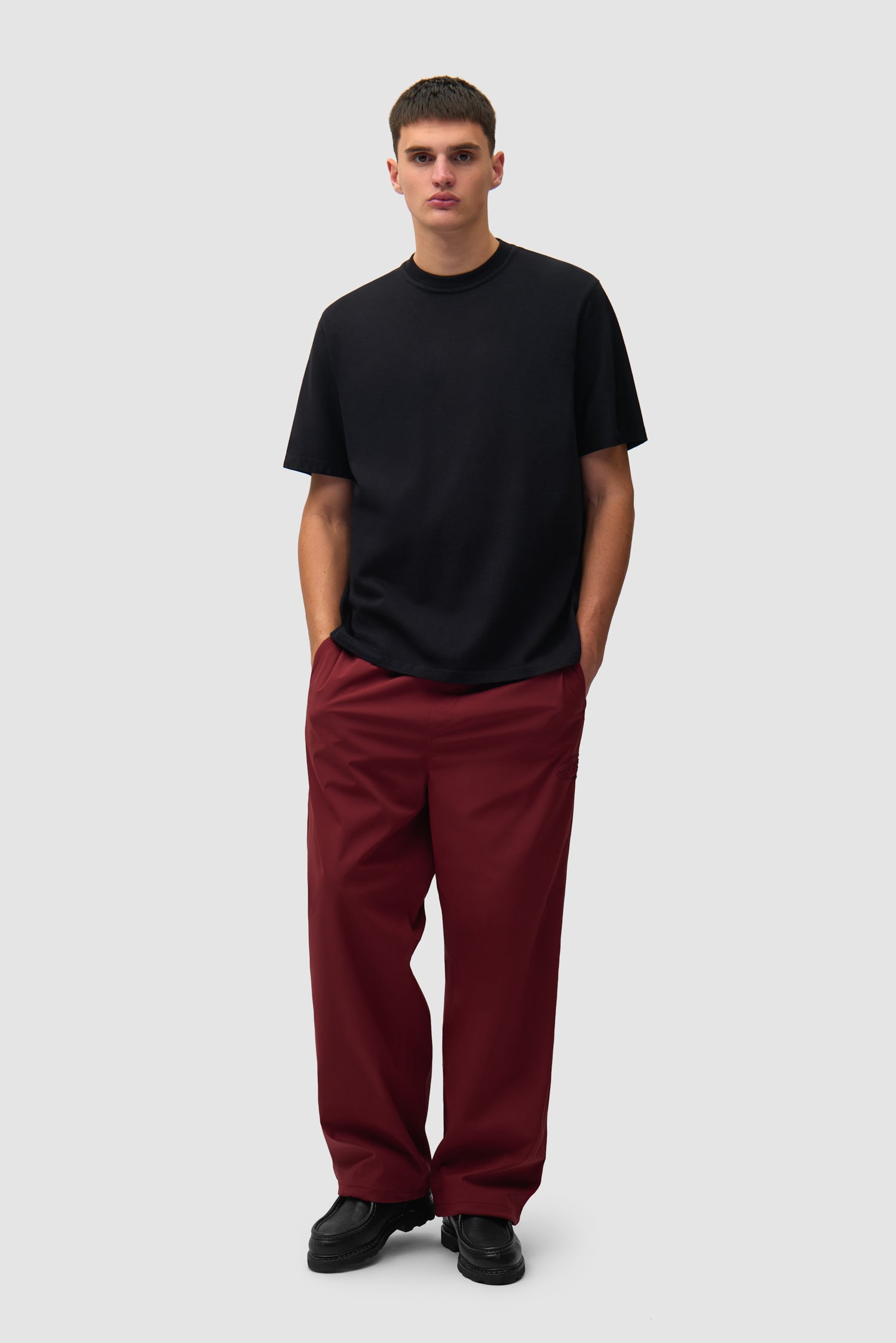 T-shirt SS26 noir porté par un mannequin, vue de face en pied