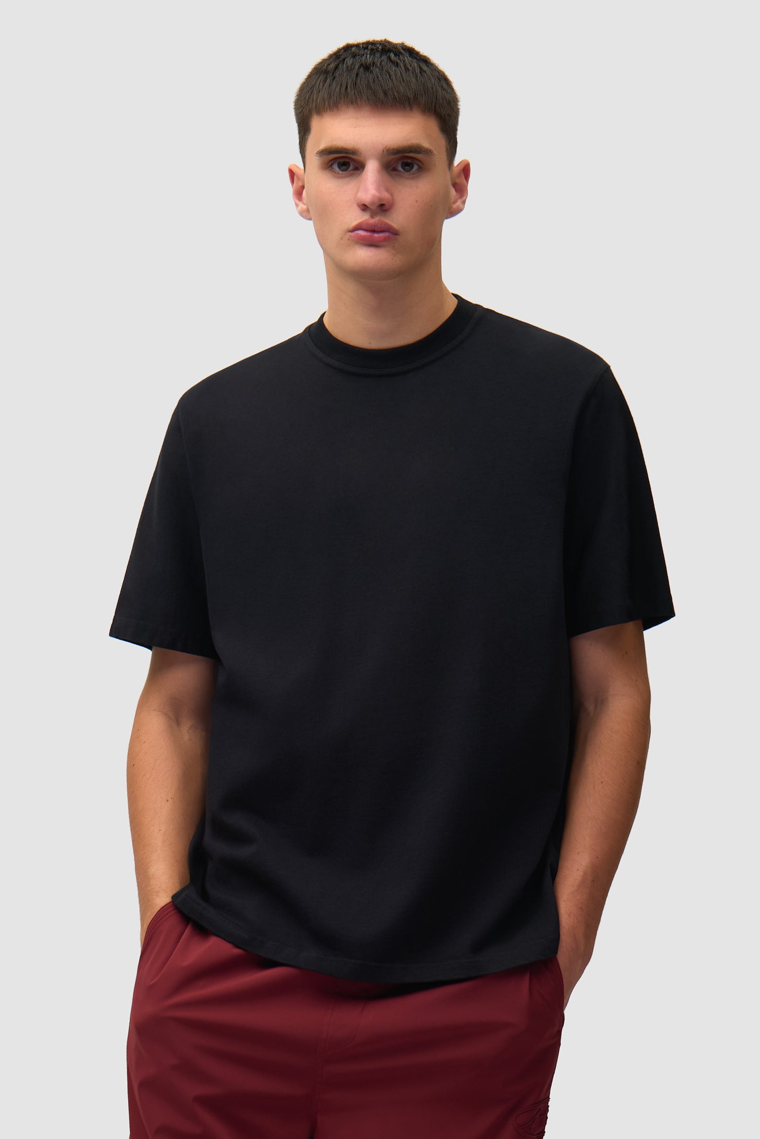 T-shirt SS26 noir porté par un mannequin, vue de face en demi-corps