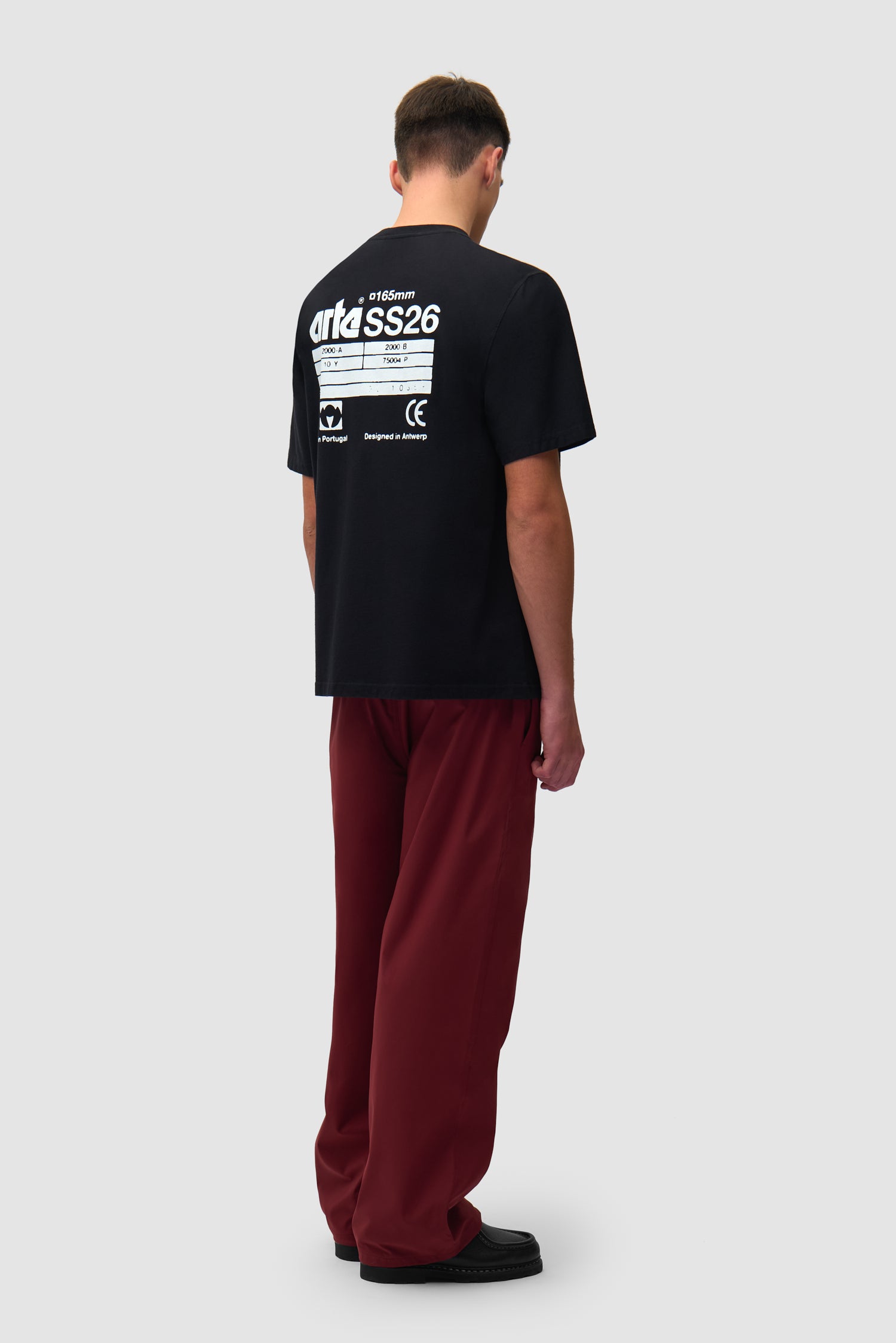 T-shirt SS26 noir porté par un mannequin, vue arrière intégrale