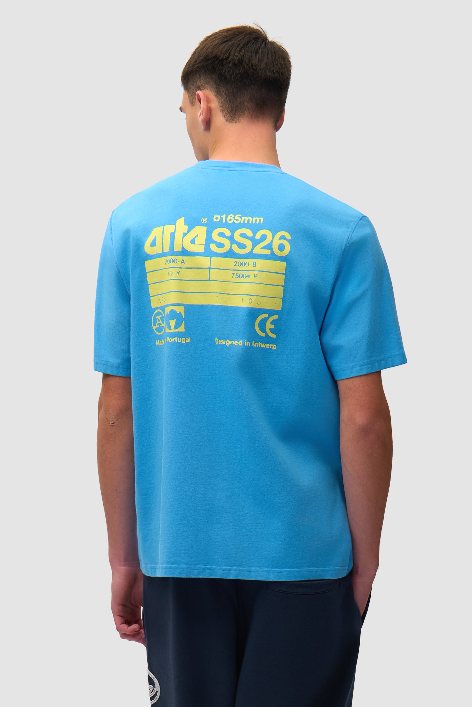 T-shirt SS26 bleu porté par un mannequin, vue de dos à mi-corps