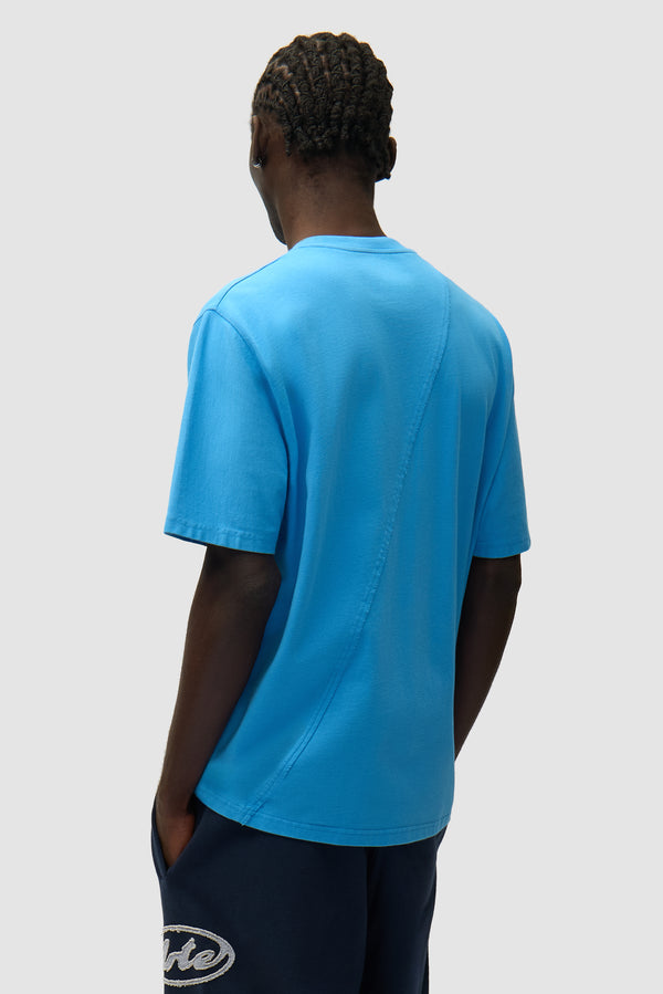 Circle Logo T-shirt in Blue worn by a model, half-body back view