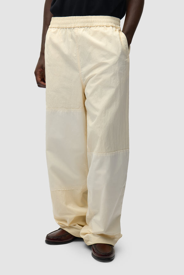 Squared Track Pants in Cream worn by a model, half-body front view