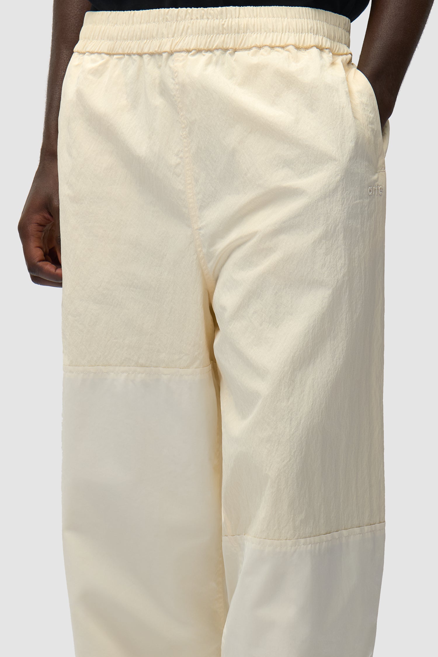 Vue détaillée du pantalon de survêtement carré couleur crème, avec logo