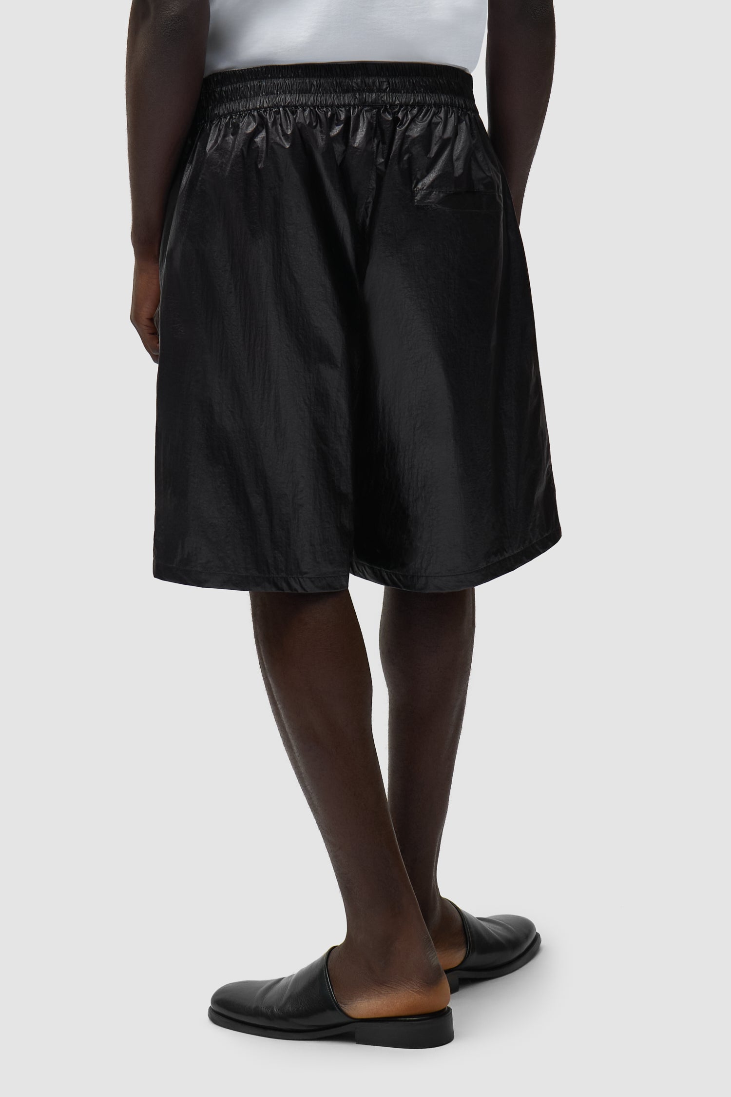 Short à grand logo noir porté par un mannequin, vue de dos à mi-corps