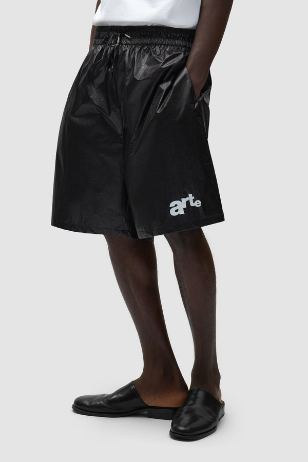 Big Logo Shorts in Black worn by a model, half-body side view