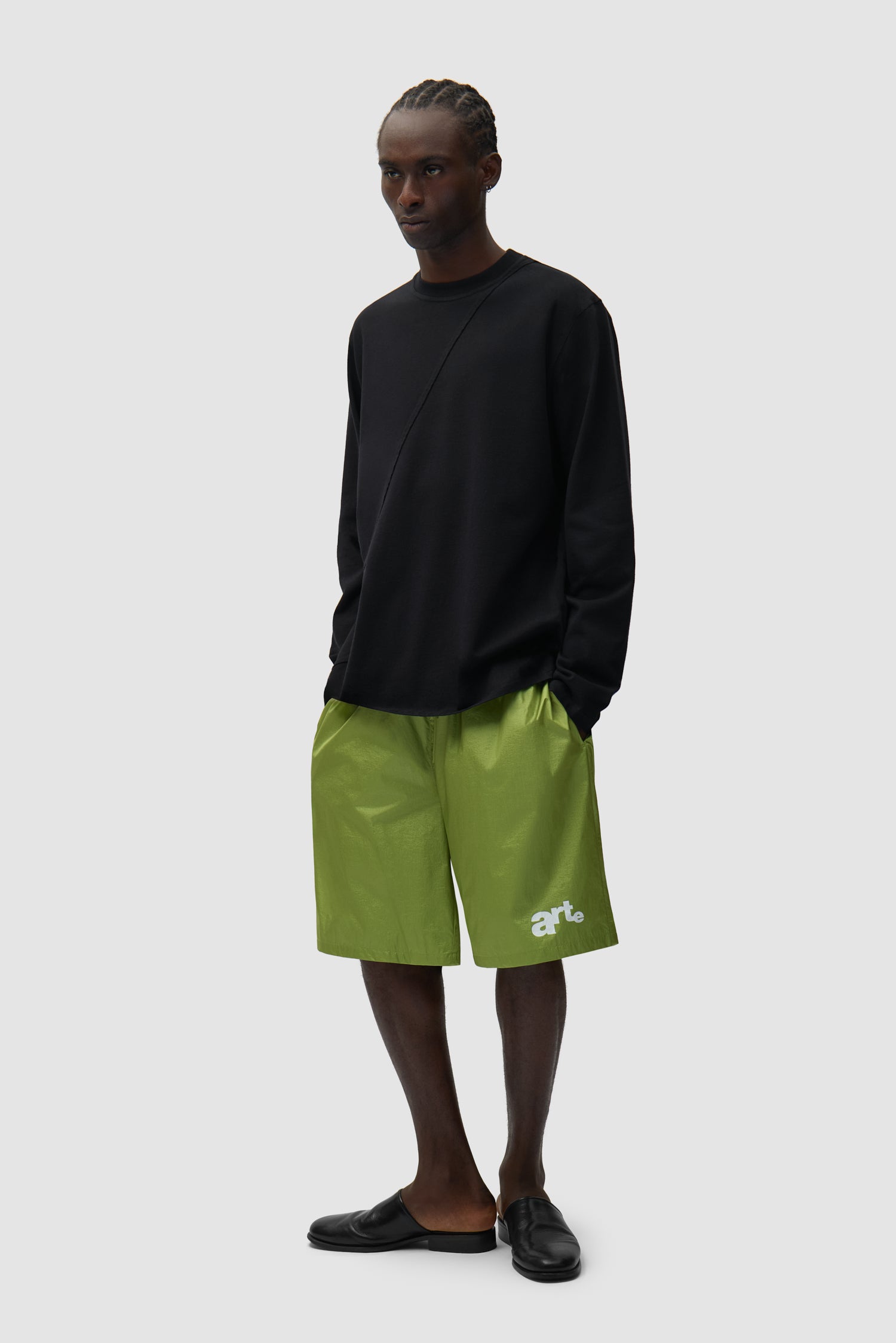 Short à grand logo vert porté par un mannequin, vue de face en pied