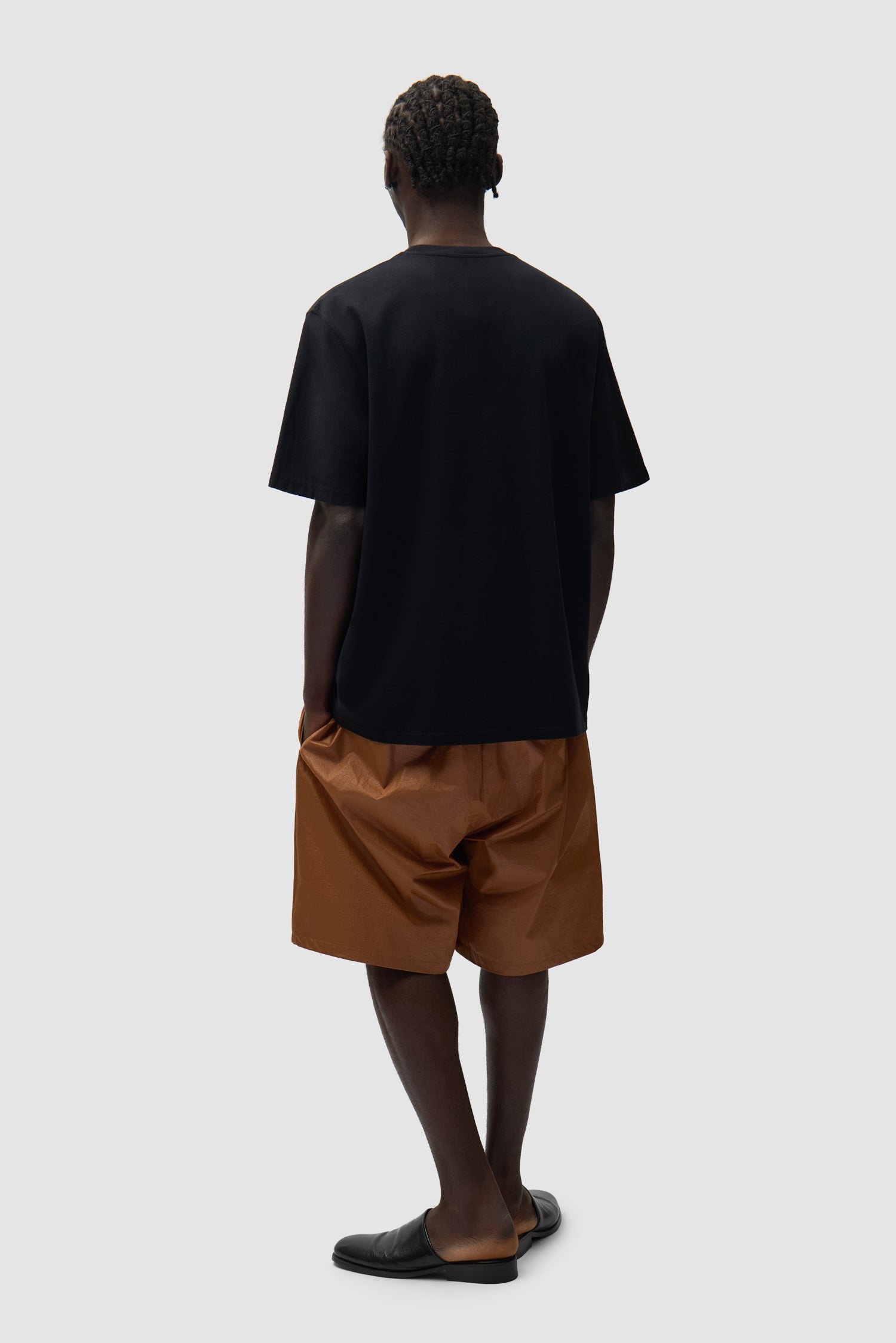 Short à grand logo orange porté par un mannequin, vue arrière en pied