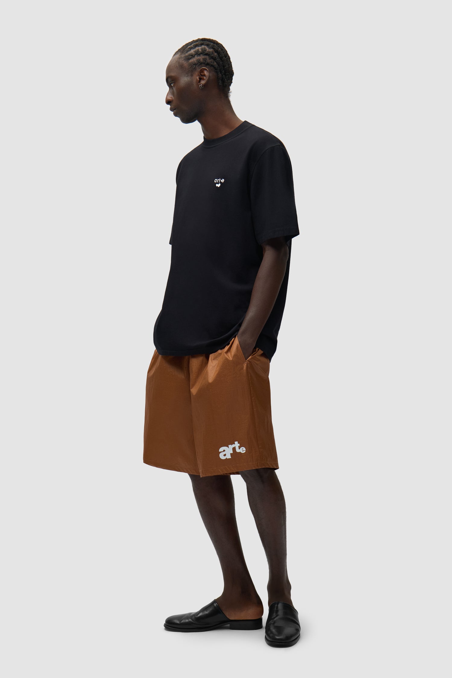 Short à grand logo orange porté par un mannequin, vue de face en pied