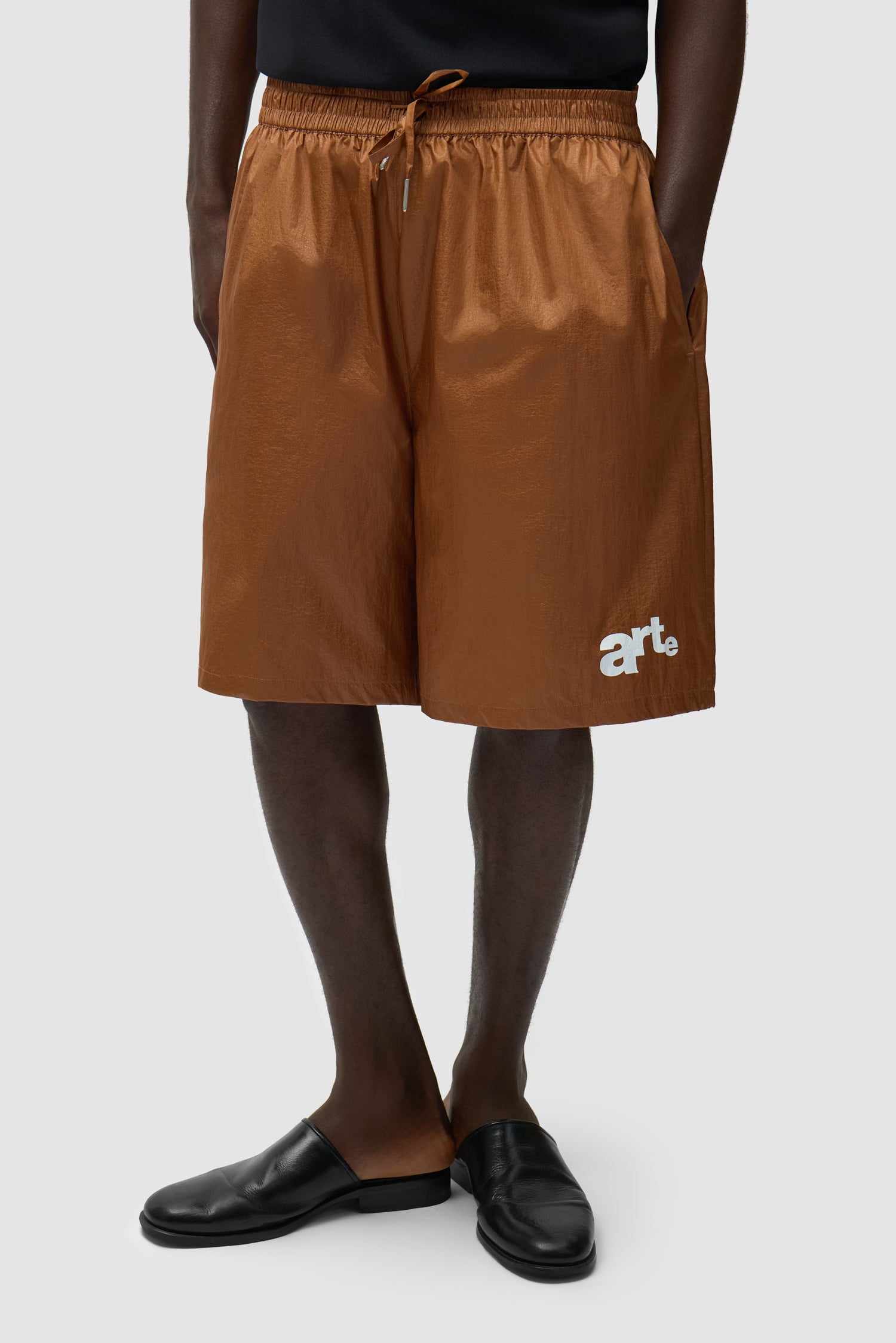 Short à grand logo orange porté par un mannequin, vue de face à mi-corps