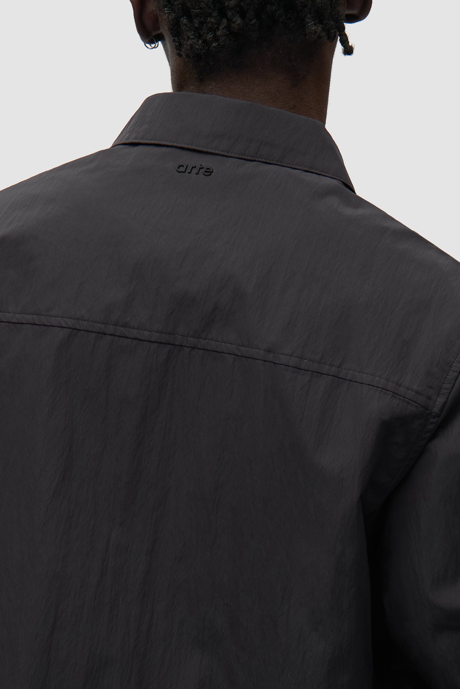 Detail view of Linen Tape Classic Jacket in Black, showing back logo