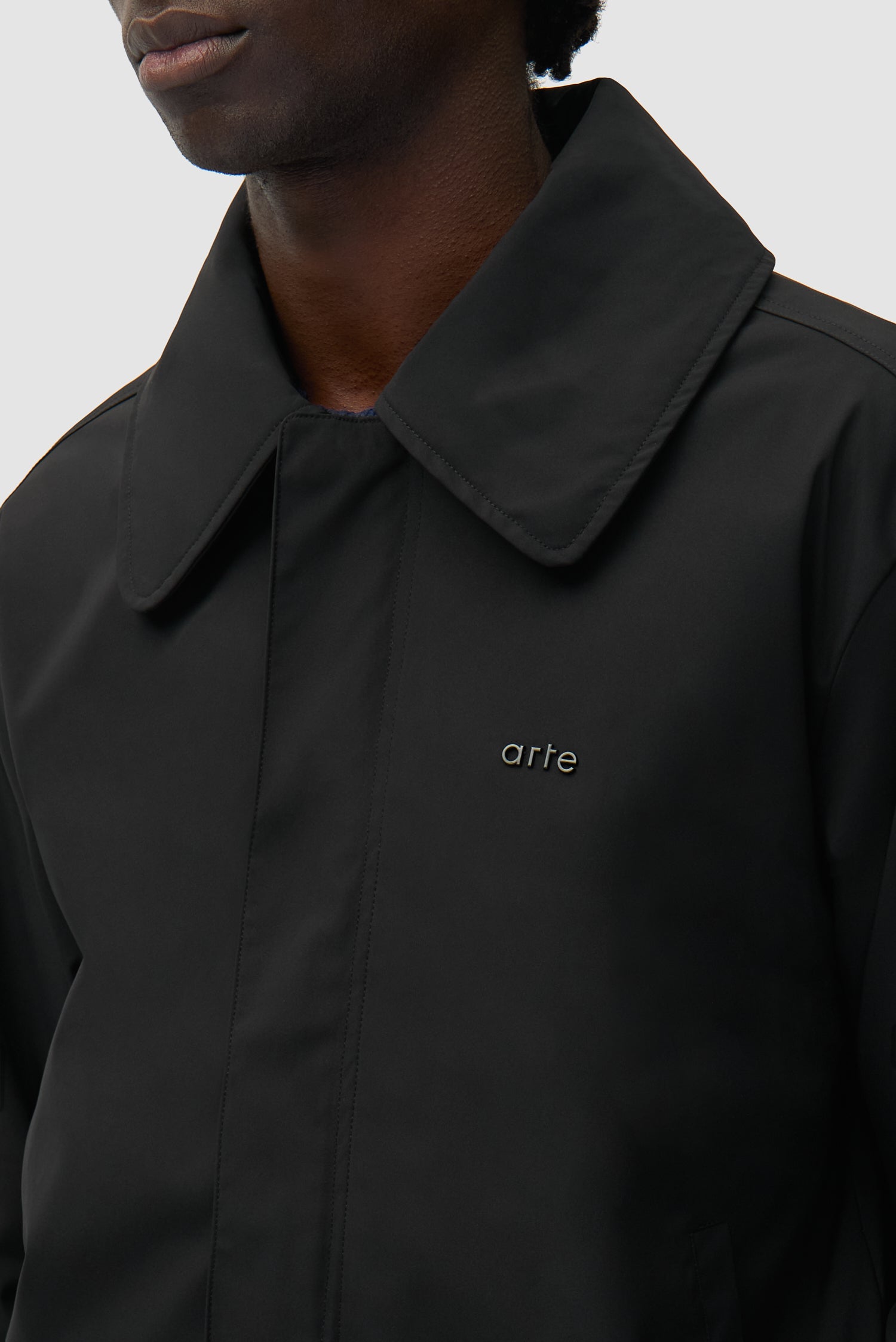 Detail view of Big Collar Nylon Jacket in Black, showing front logo