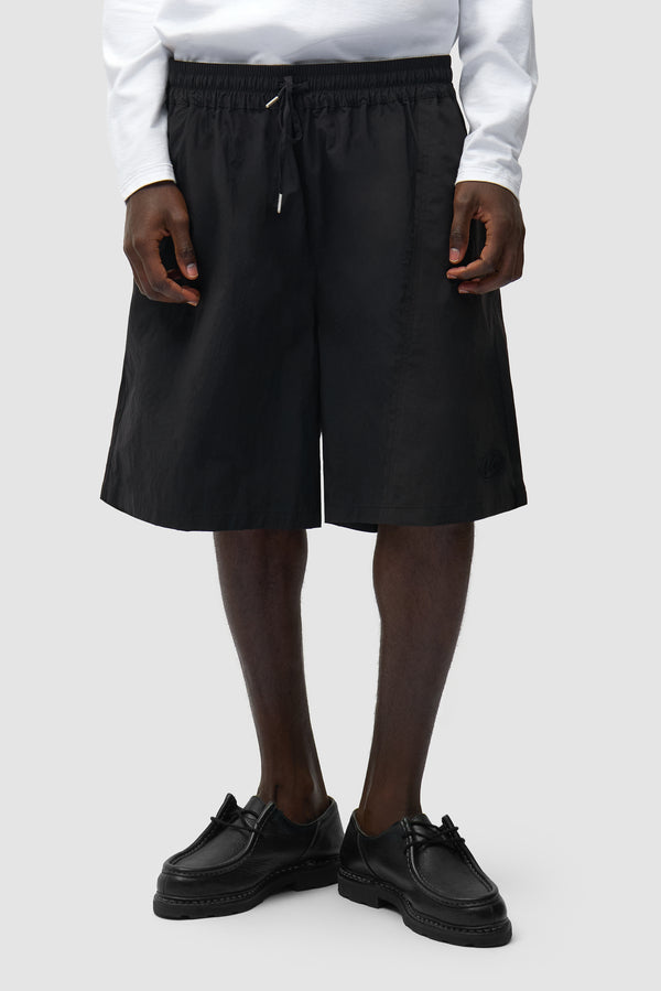 Distorted Shorts in Black worn by a model, half-body front view