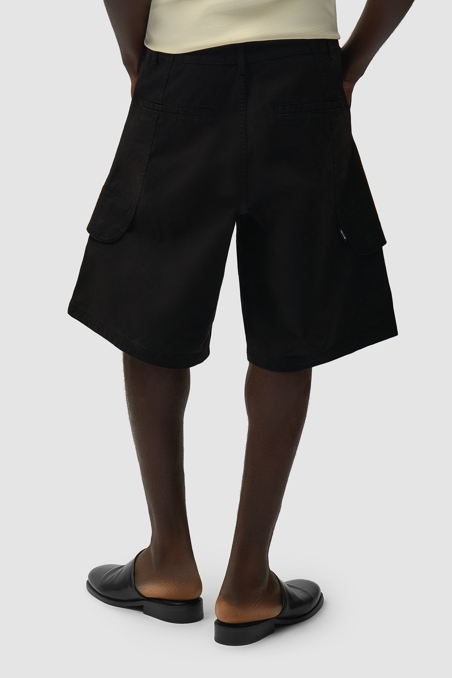 Short cargo en toile noir porté par un mannequin, vue de profil