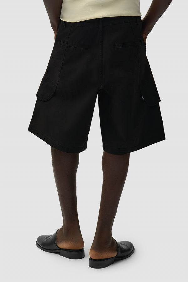 Canvas Cargo Shorts in Black worn by a model, half-body side view