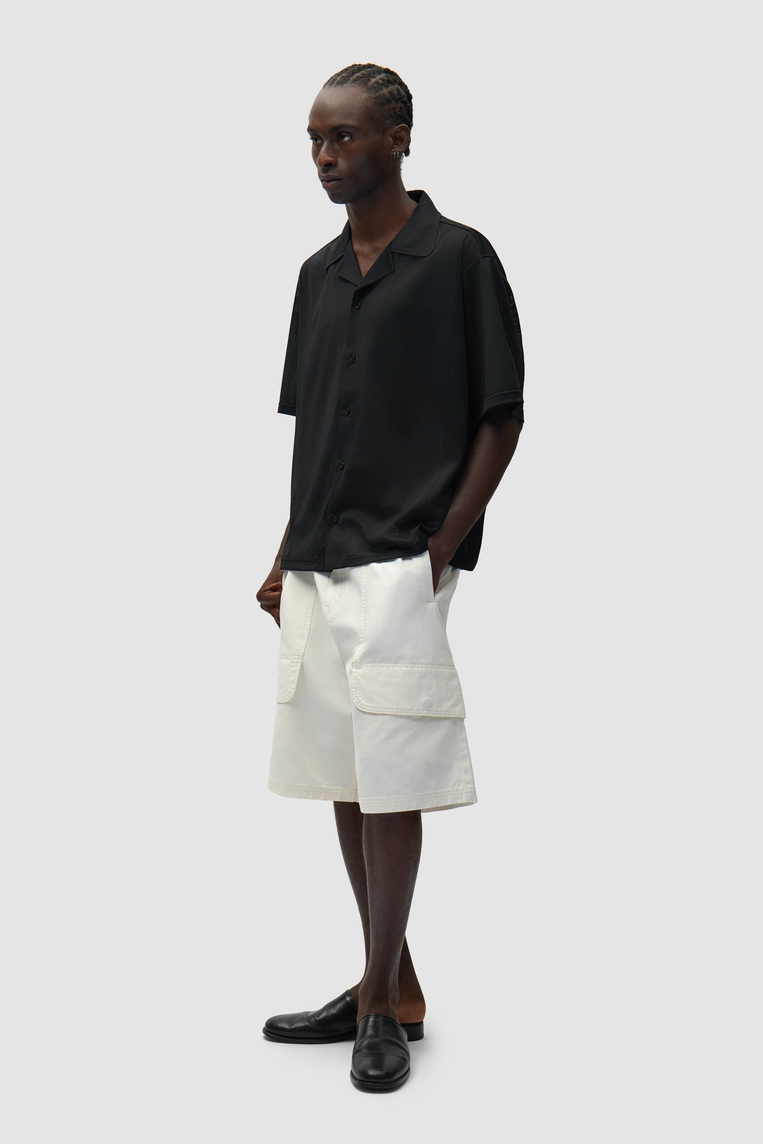 Short cargo en toile couleur crème porté par un mannequin, vue de profil en pied