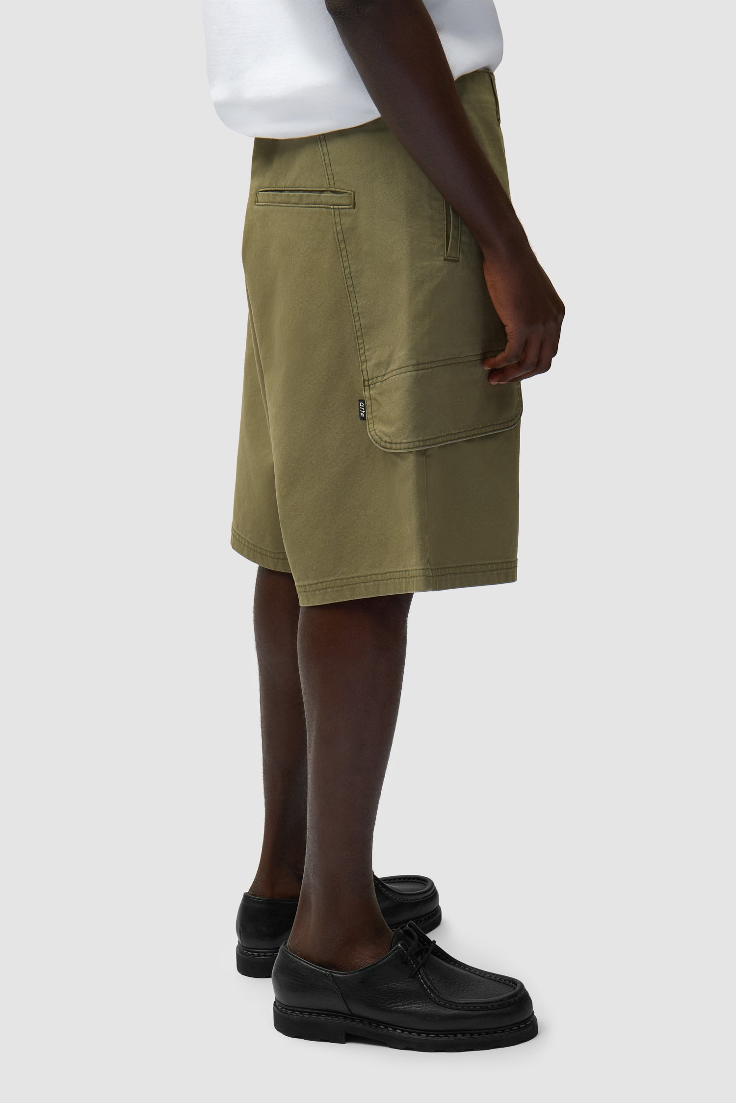 Short cargo en toile vert porté par un mannequin, vue de profil à mi-corps