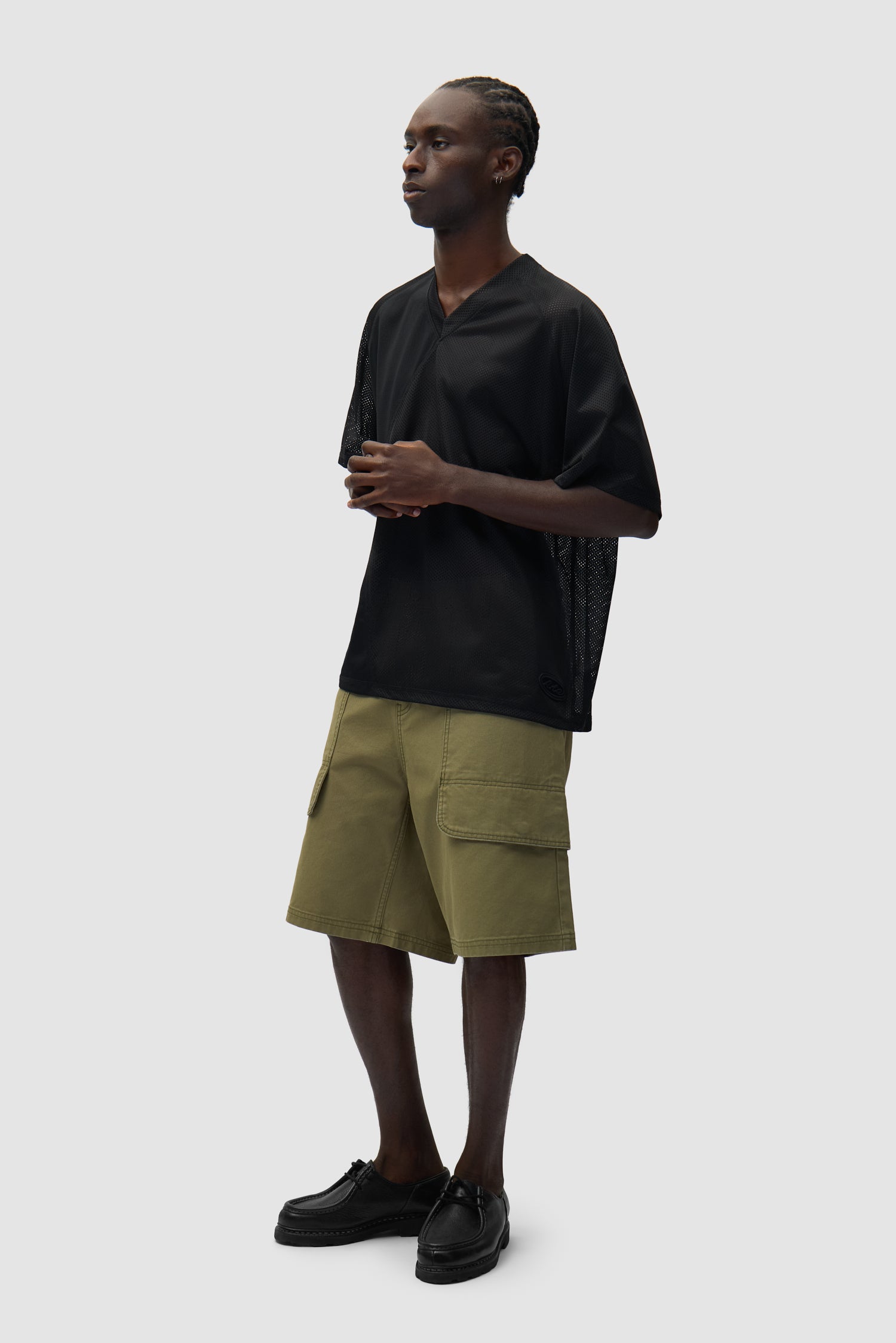 Short cargo en toile vert porté par un mannequin, vue de profil en pied