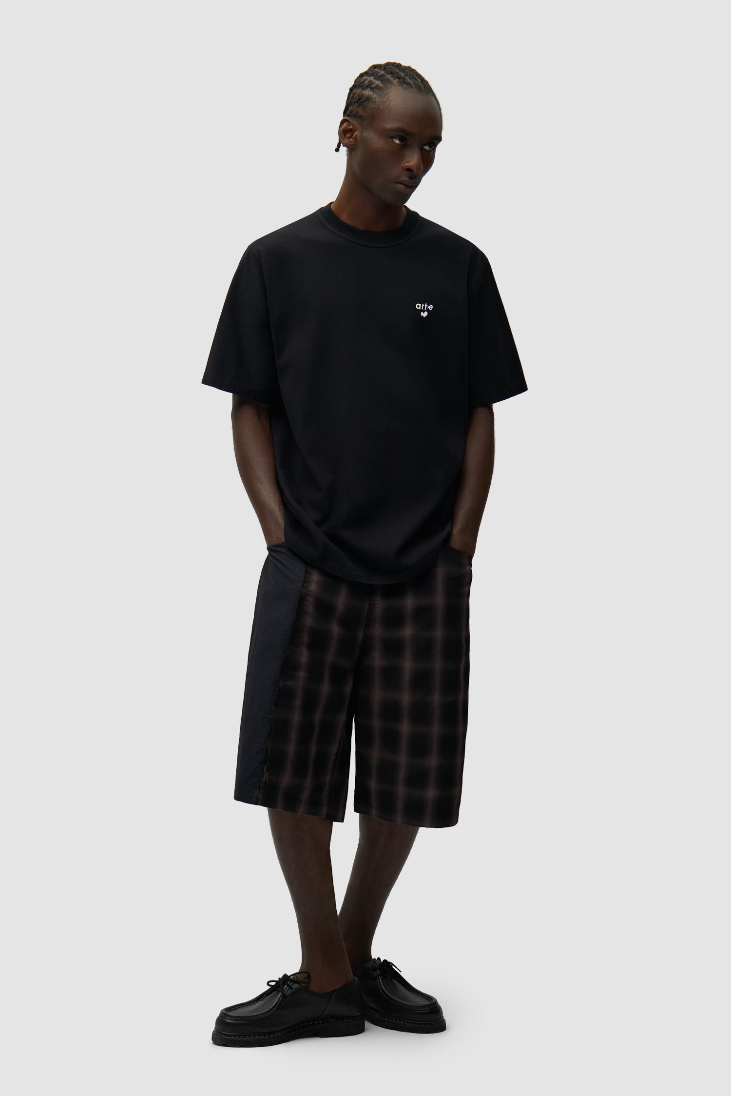 T-shirt noir avec logo en forme de cœur porté par un mannequin, vue de profil en pied