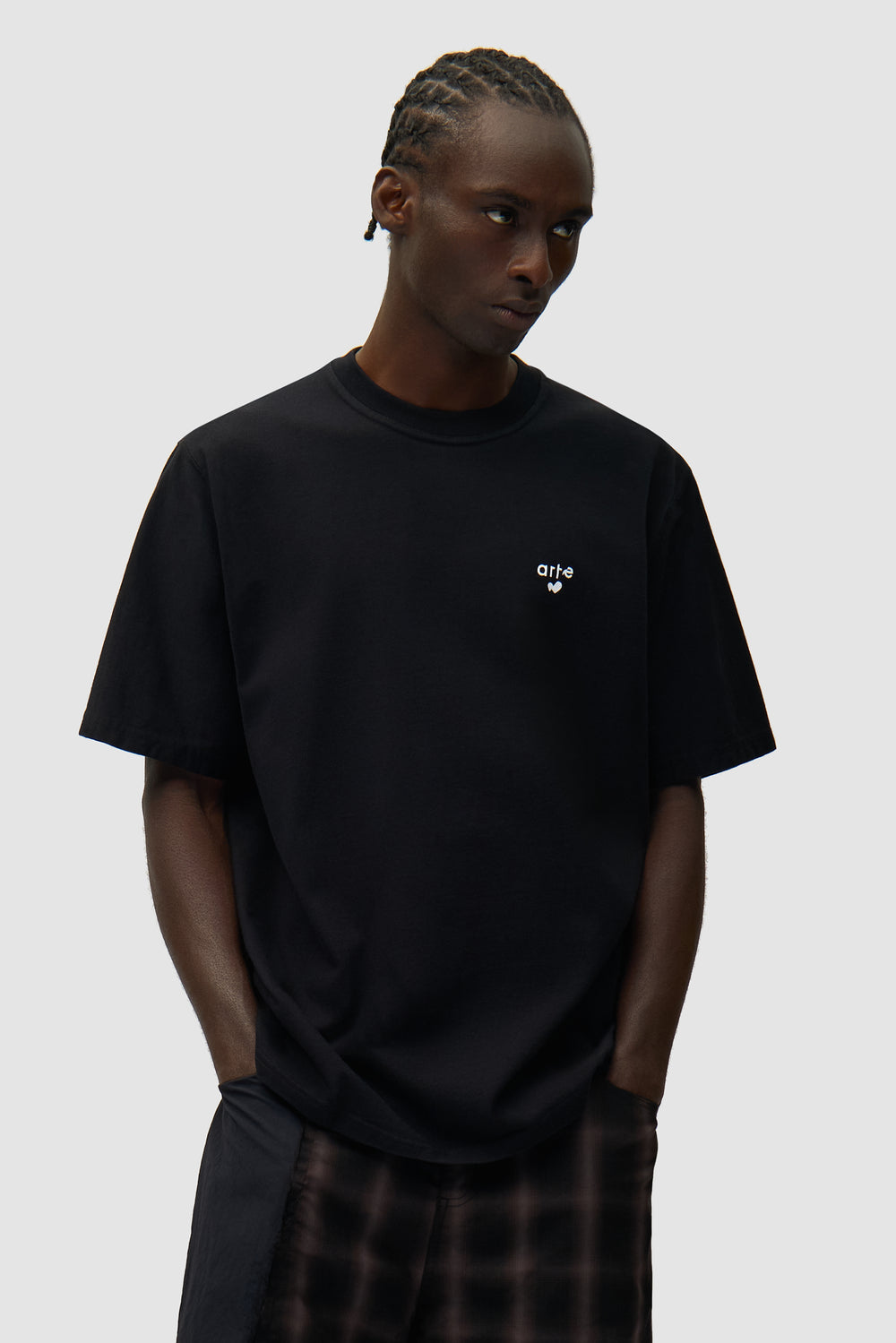 T-shirt noir avec logo en forme de cœur porté par un mannequin, vue de face, demi-corps