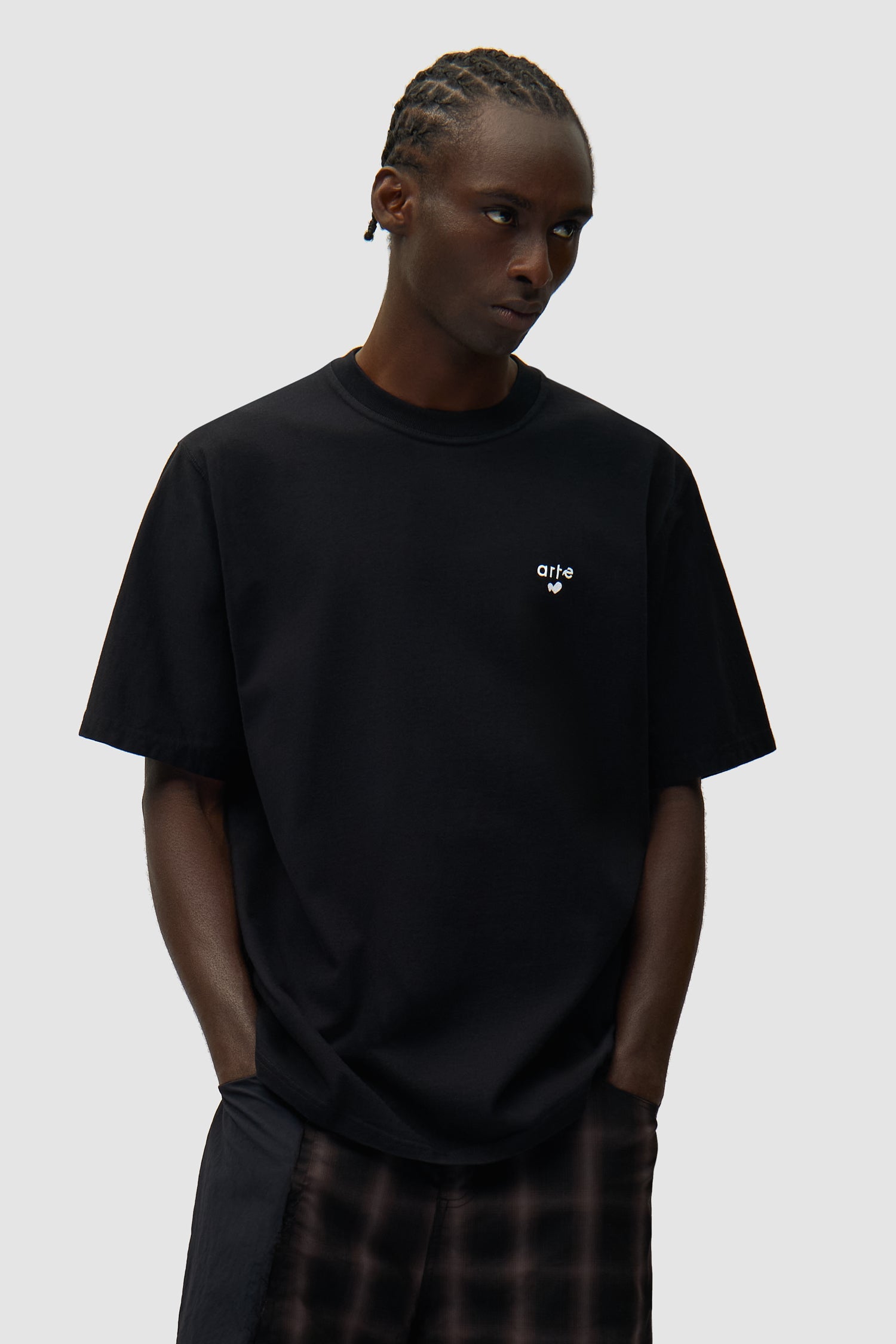 T-shirt noir avec logo en forme de cœur porté par un mannequin, vue de face, demi-corps