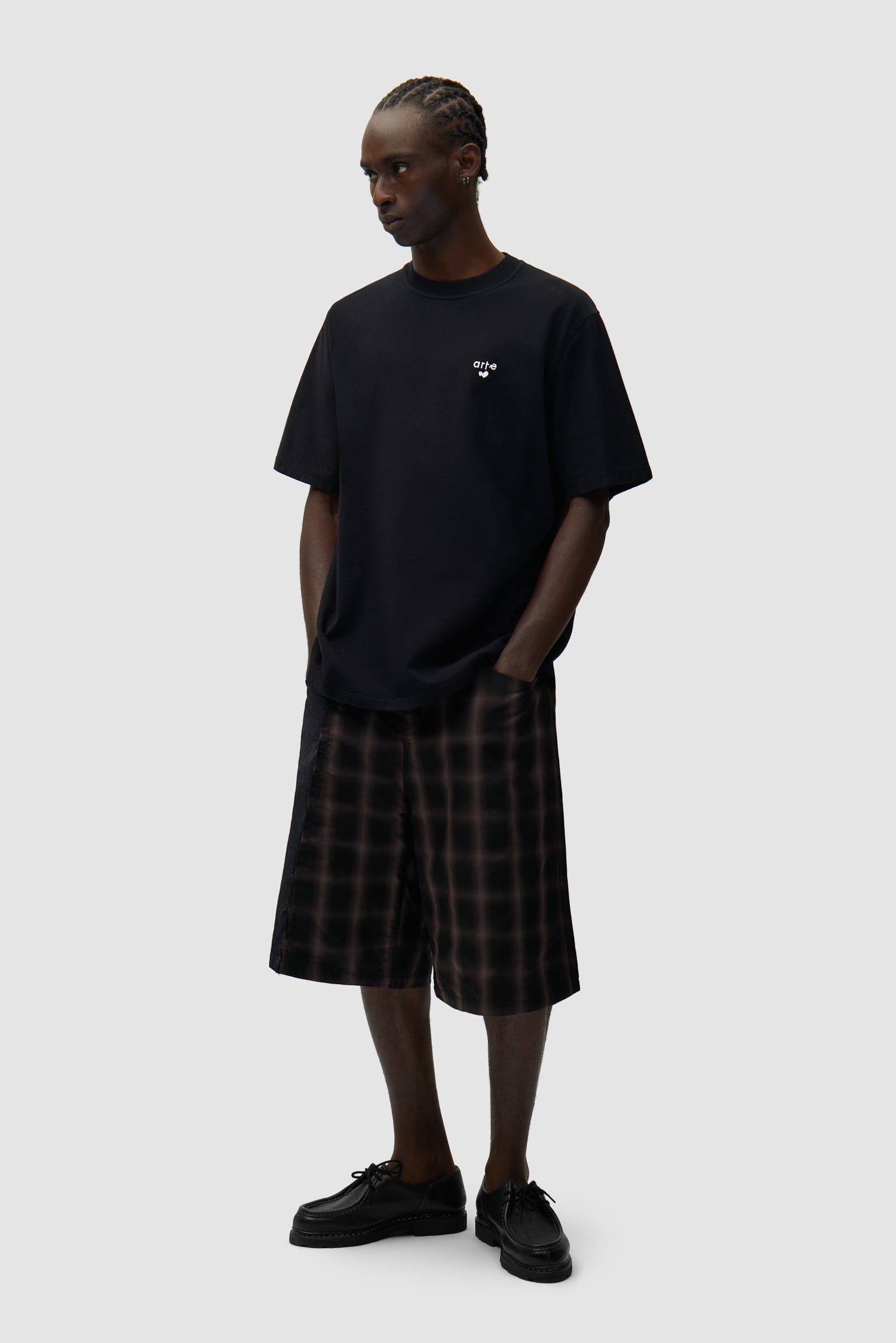 T-shirt noir avec logo en forme de cœur porté par un mannequin, vue de face en pied