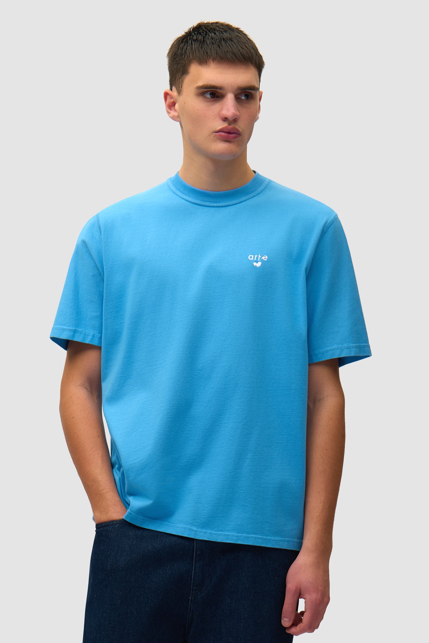 T-shirt bleu avec logo en forme de cœur porté par un mannequin, vue de face, demi-corps