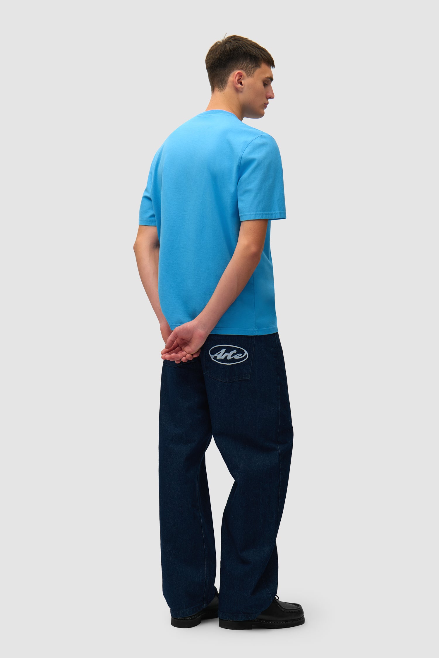 T-shirt bleu avec logo en forme de cœur porté par un mannequin, vue arrière en pied