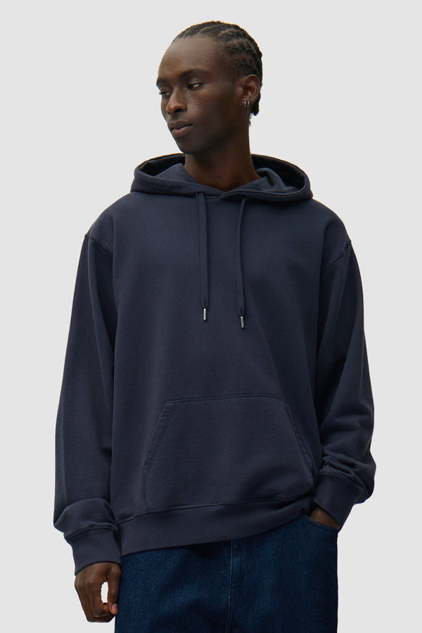 Back SS26 Hoodie in Navy worn by a model, half-body front view