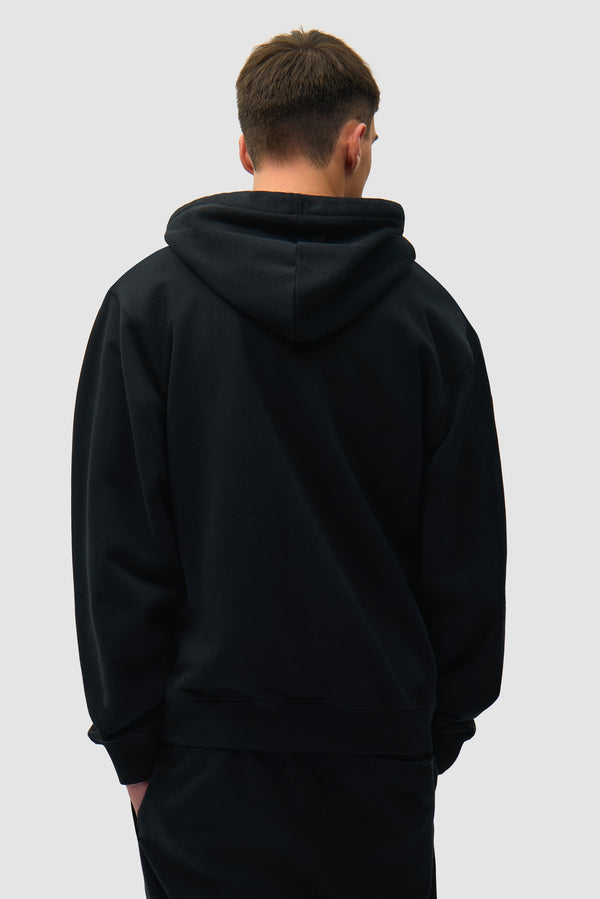 Heart Logo Hoodie in Black worn by a model, half-body back view