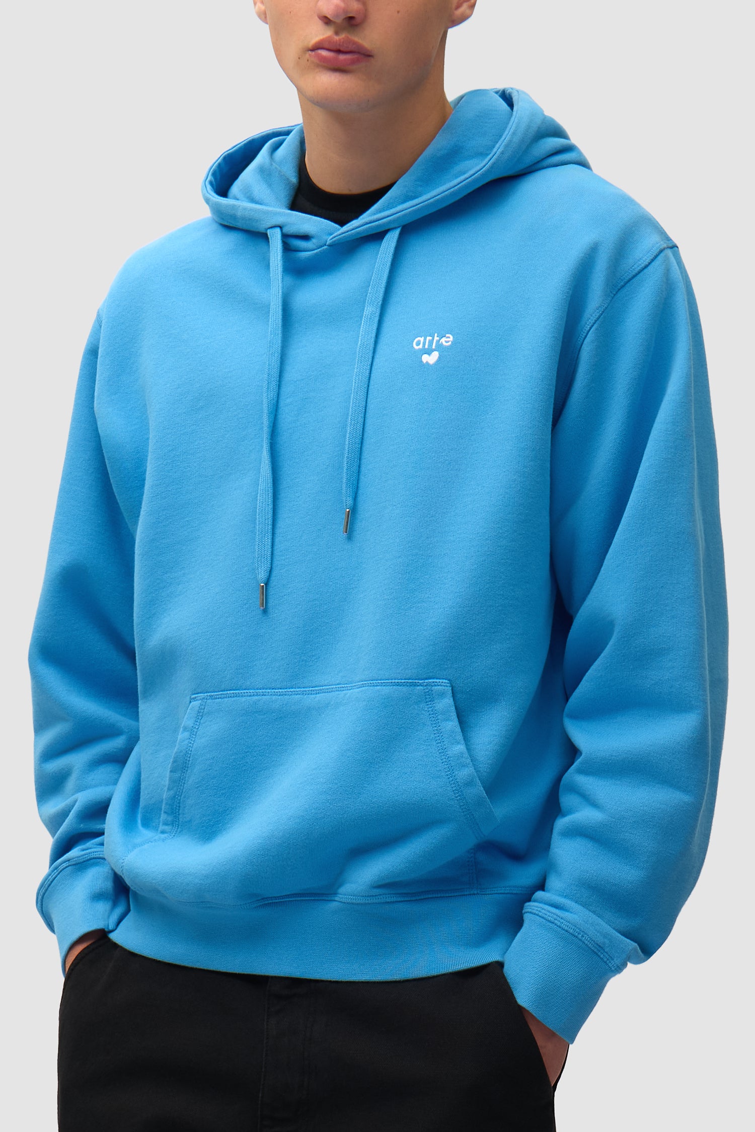 Heart Logo Hoodie in Blue worn by a model, half-body side view