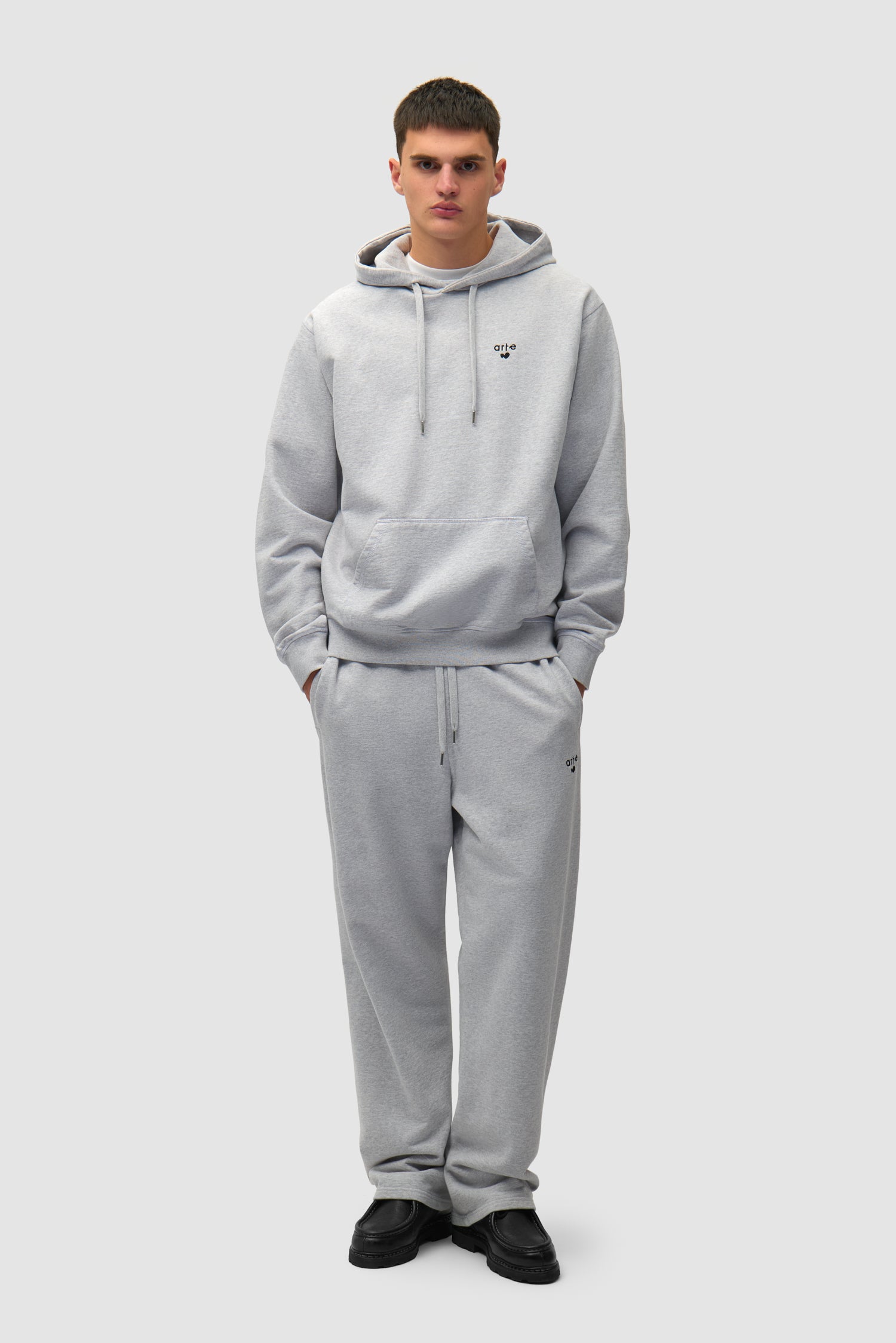 Heart Logo Hoodie in Grey worn by a model, full-body side view