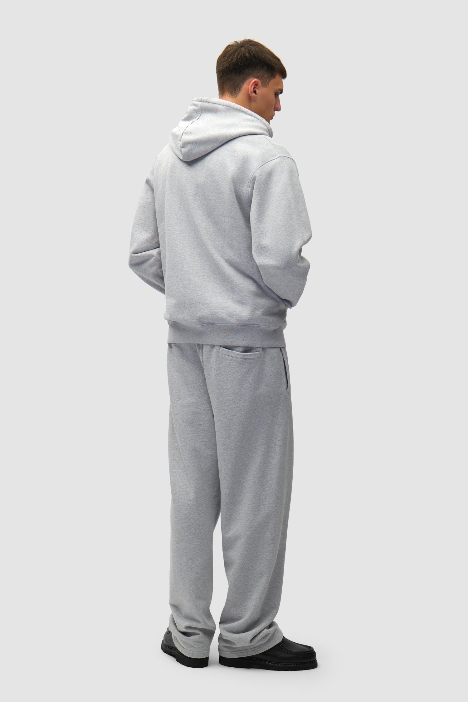 Heart Logo Hoodie in Grey worn by a model, full-body back view