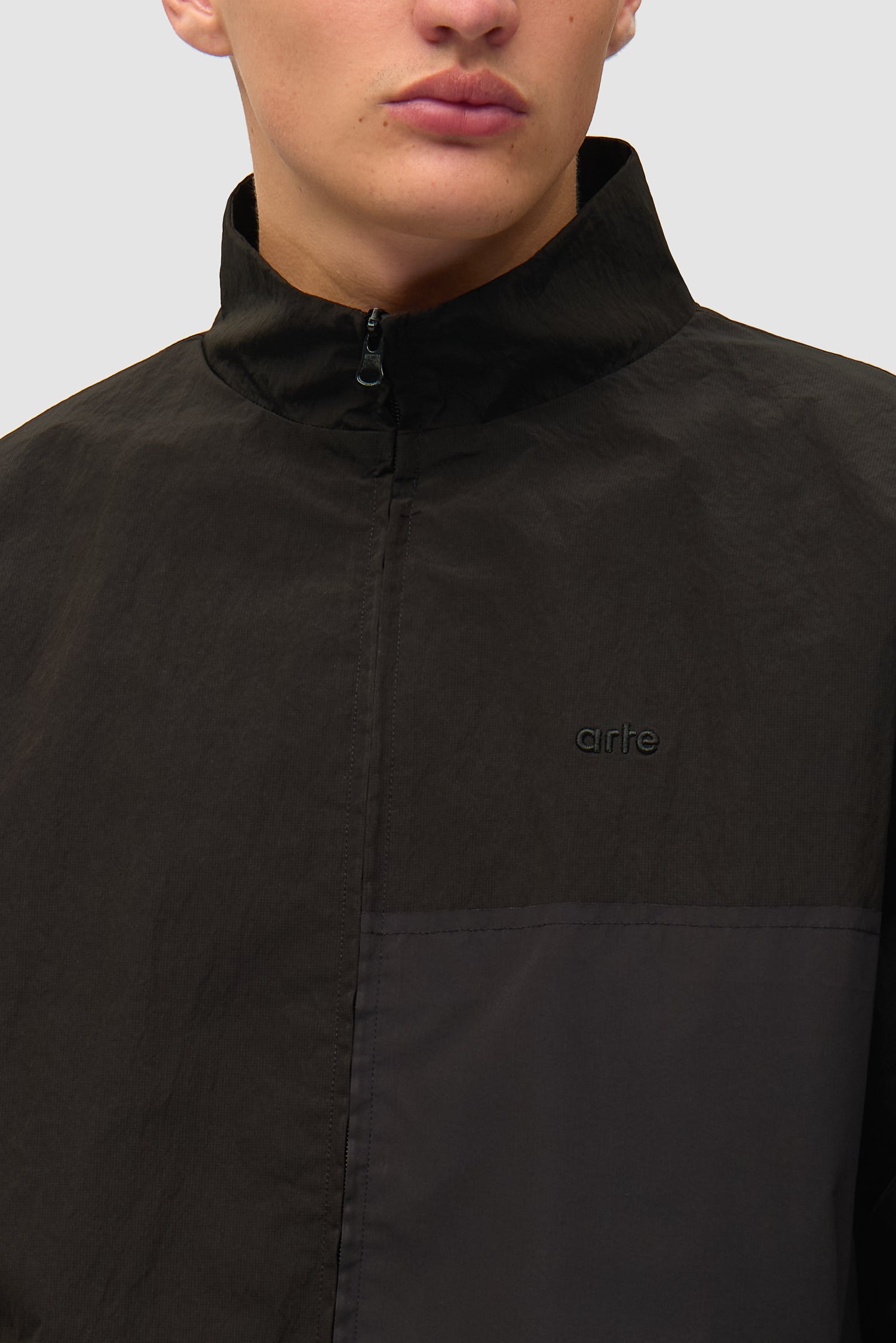 Vue détaillée de la veste de survêtement carrée noire, avec logo