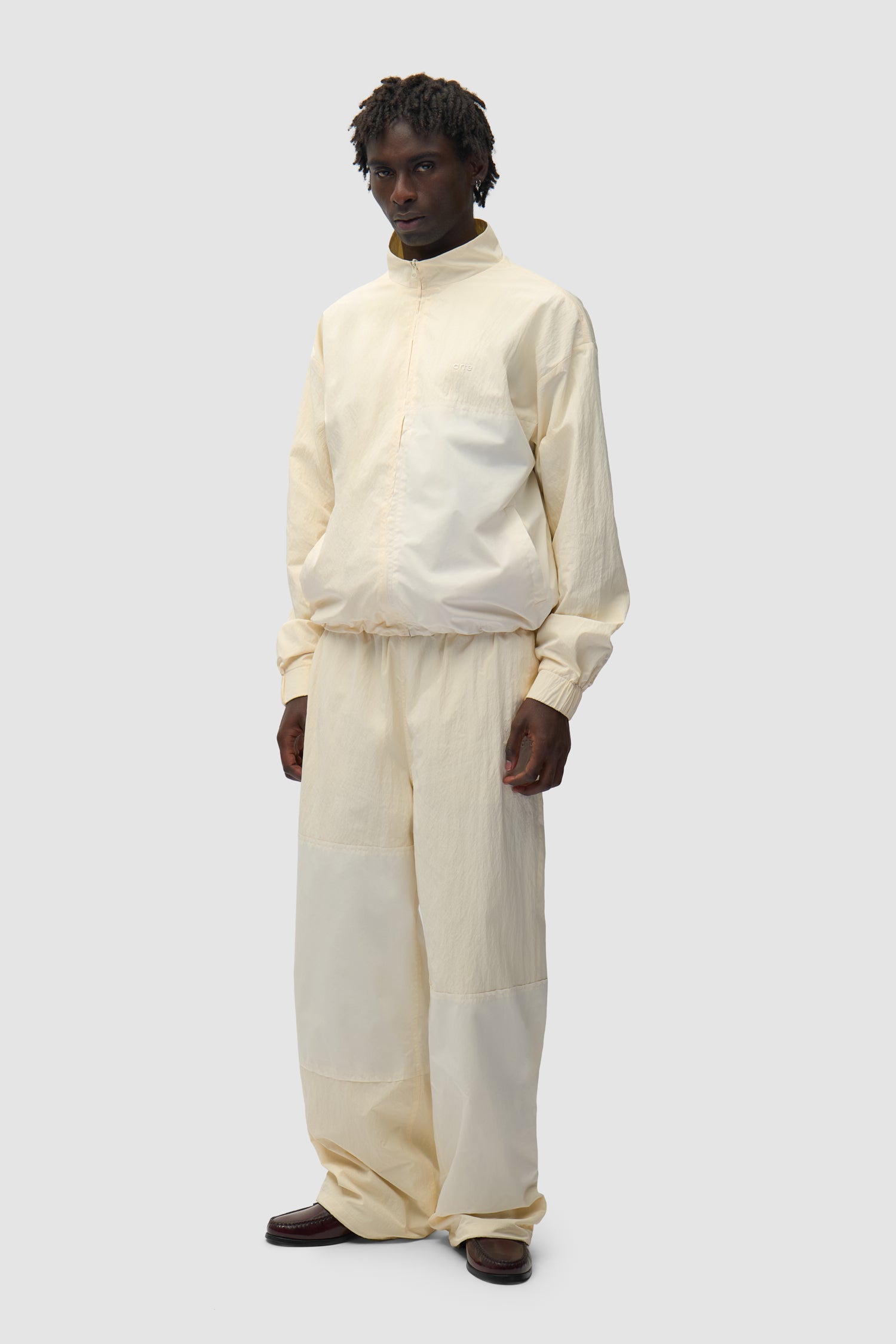 Squared Track Jacket in Cream worn by a model, full-body side view