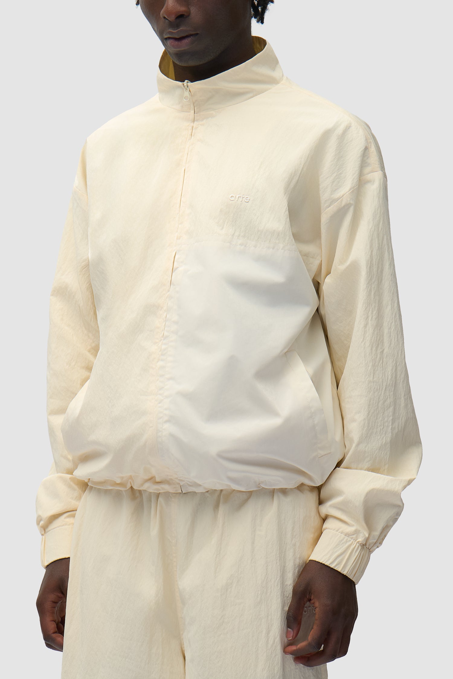 Squared Track Jacket in Cream worn by a model, half-body side view